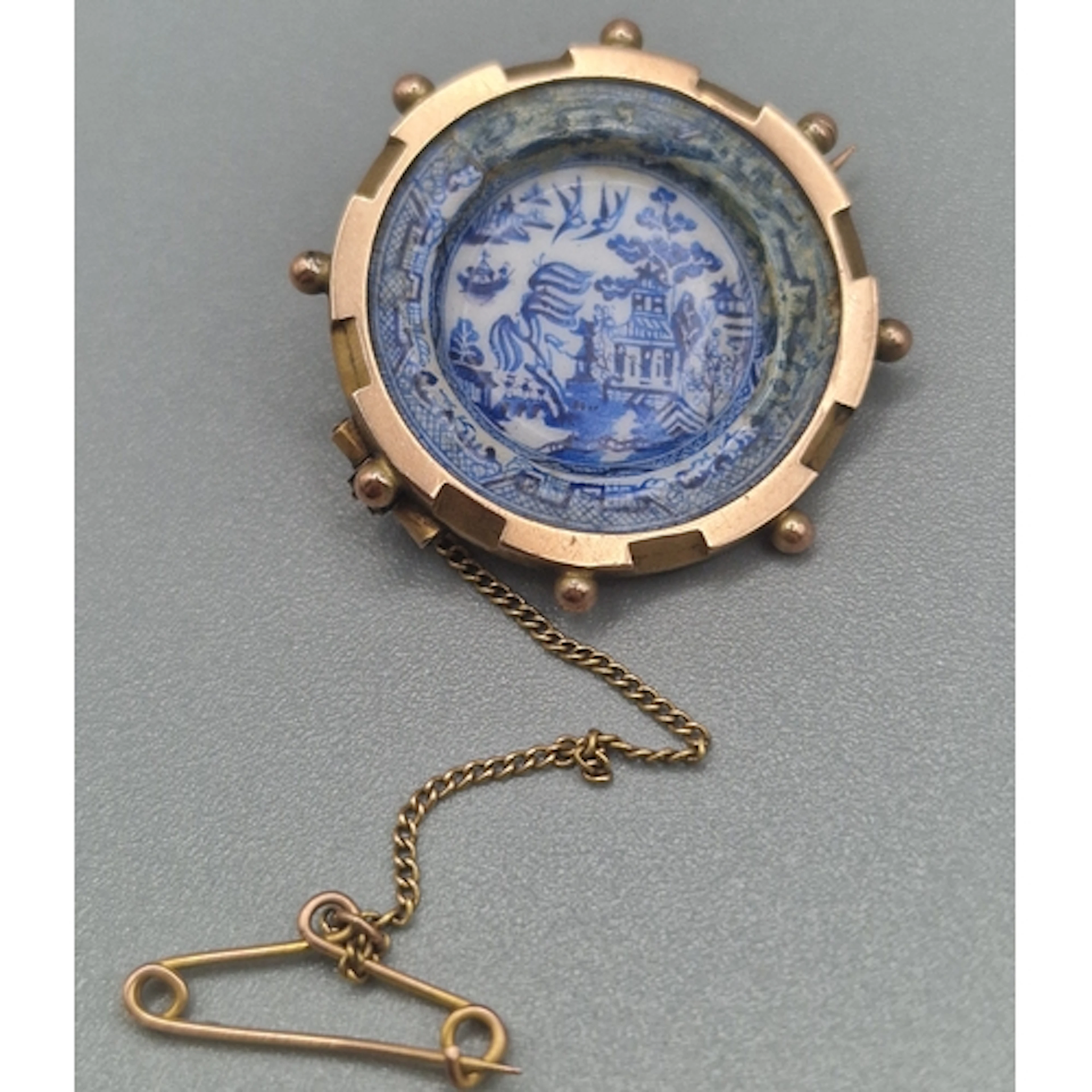Victorian yellow metal bar brooch encased in a blue and whit...