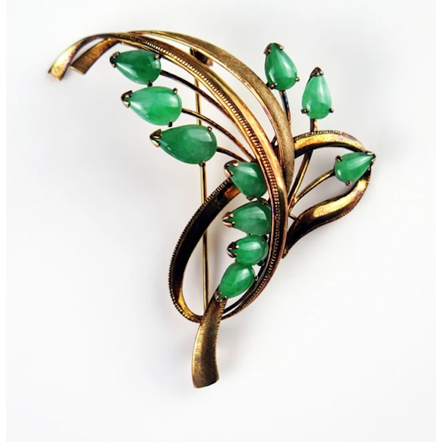 A jade foliate spray brooch in a 14K yellow gold setting, c....