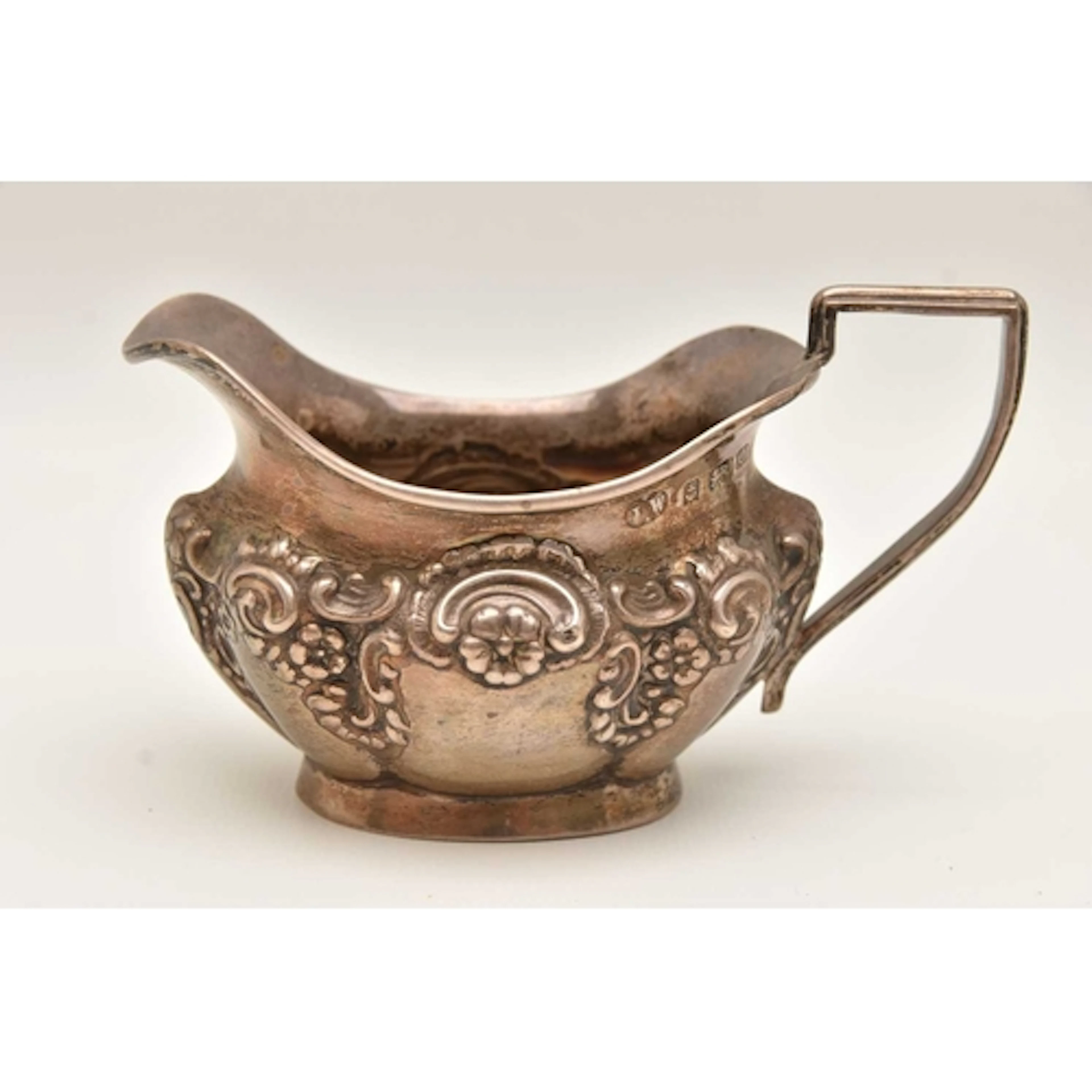 AN EDWARD VII SILVER MILK JUG, embossed floral detail, hallm...