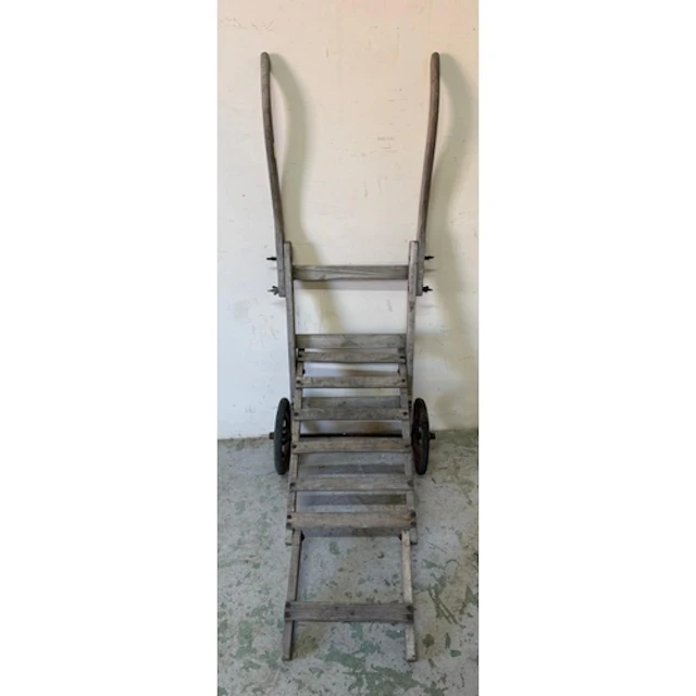 A vintage wooden sack truck with cast iron wheels.