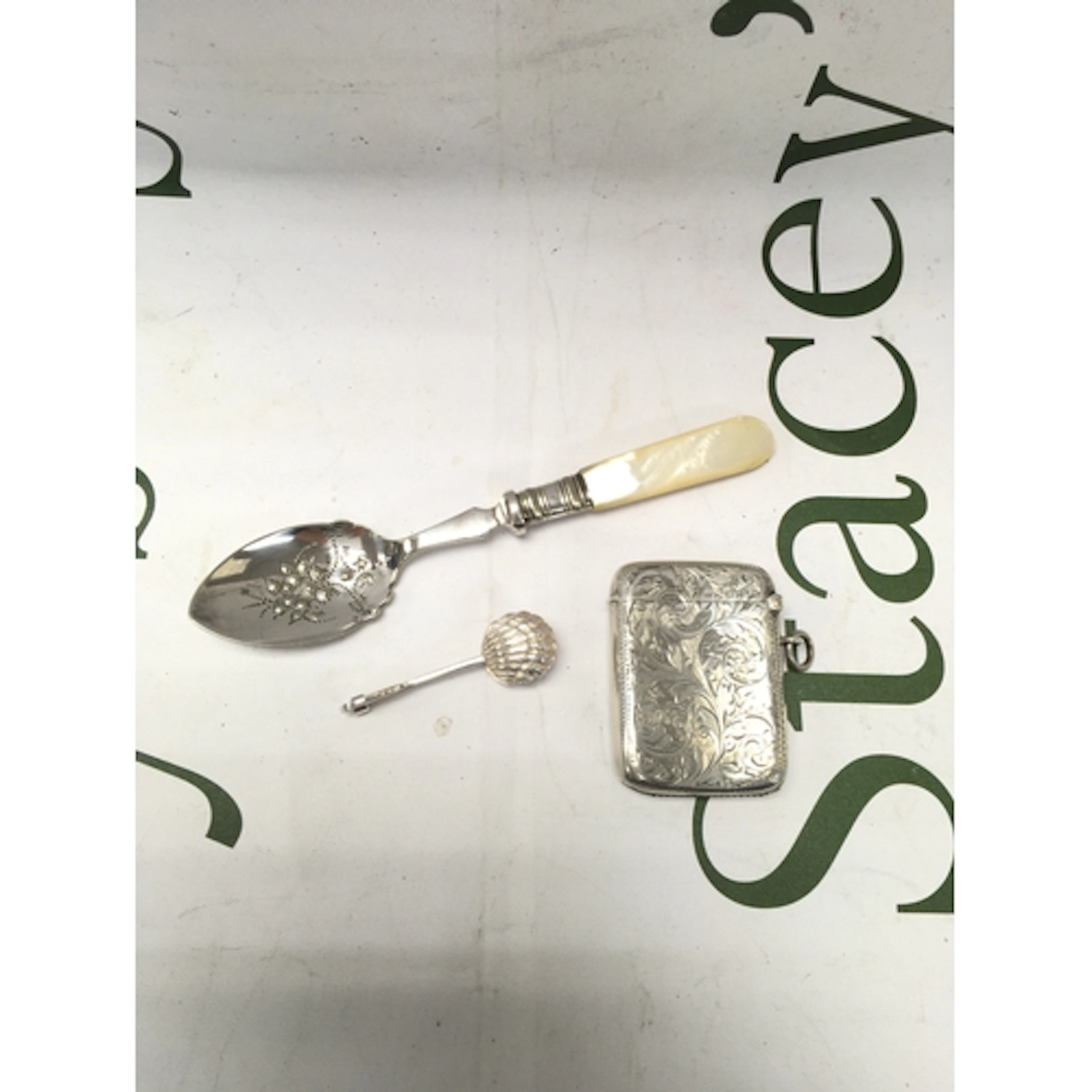A small collection of silverware including a spoon, napkin h...