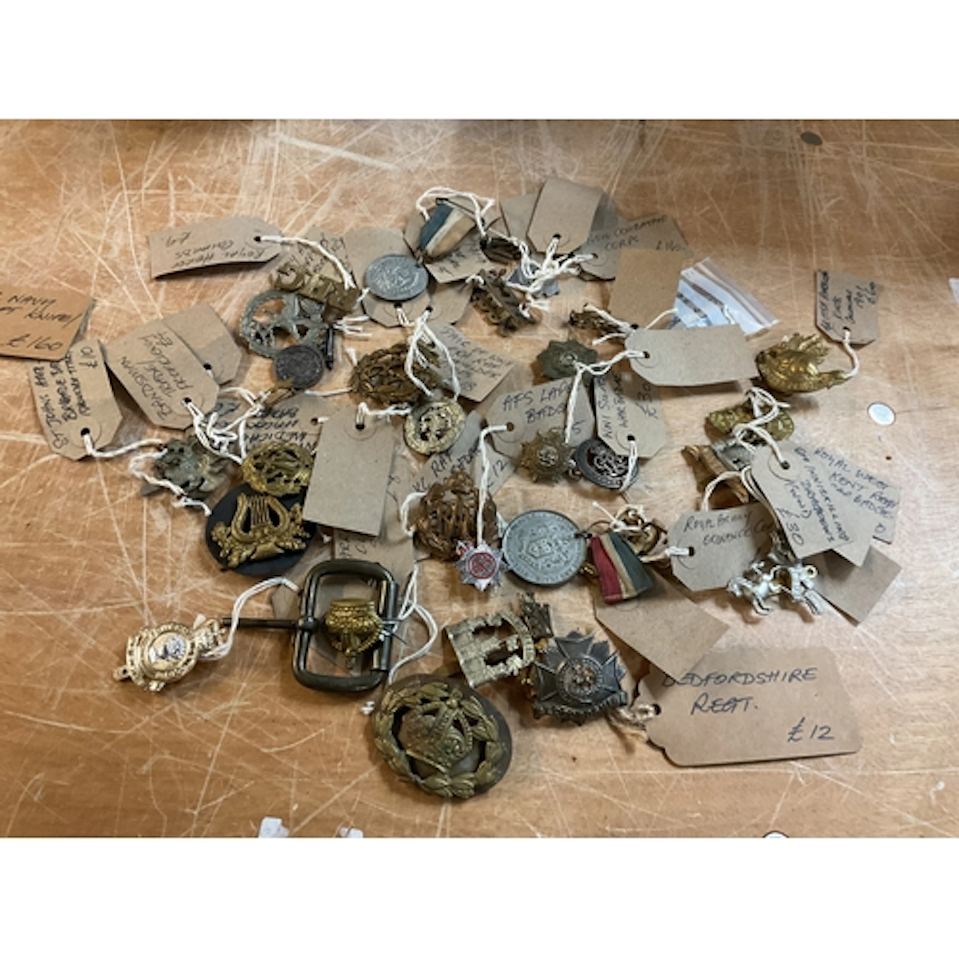 Large qty original cap badges and other insignia .