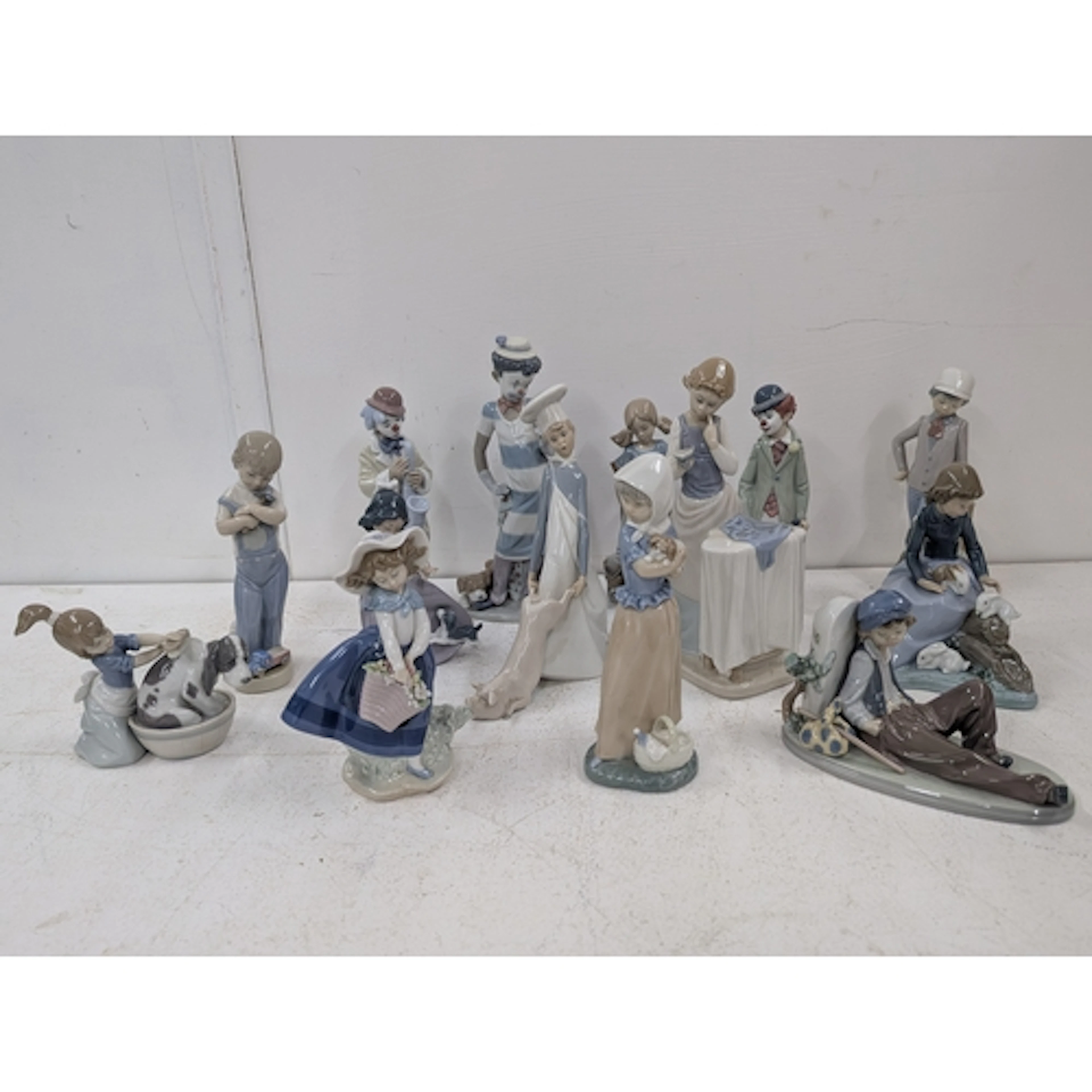 A collection of Lladro and Nao figures to include On the Mov...