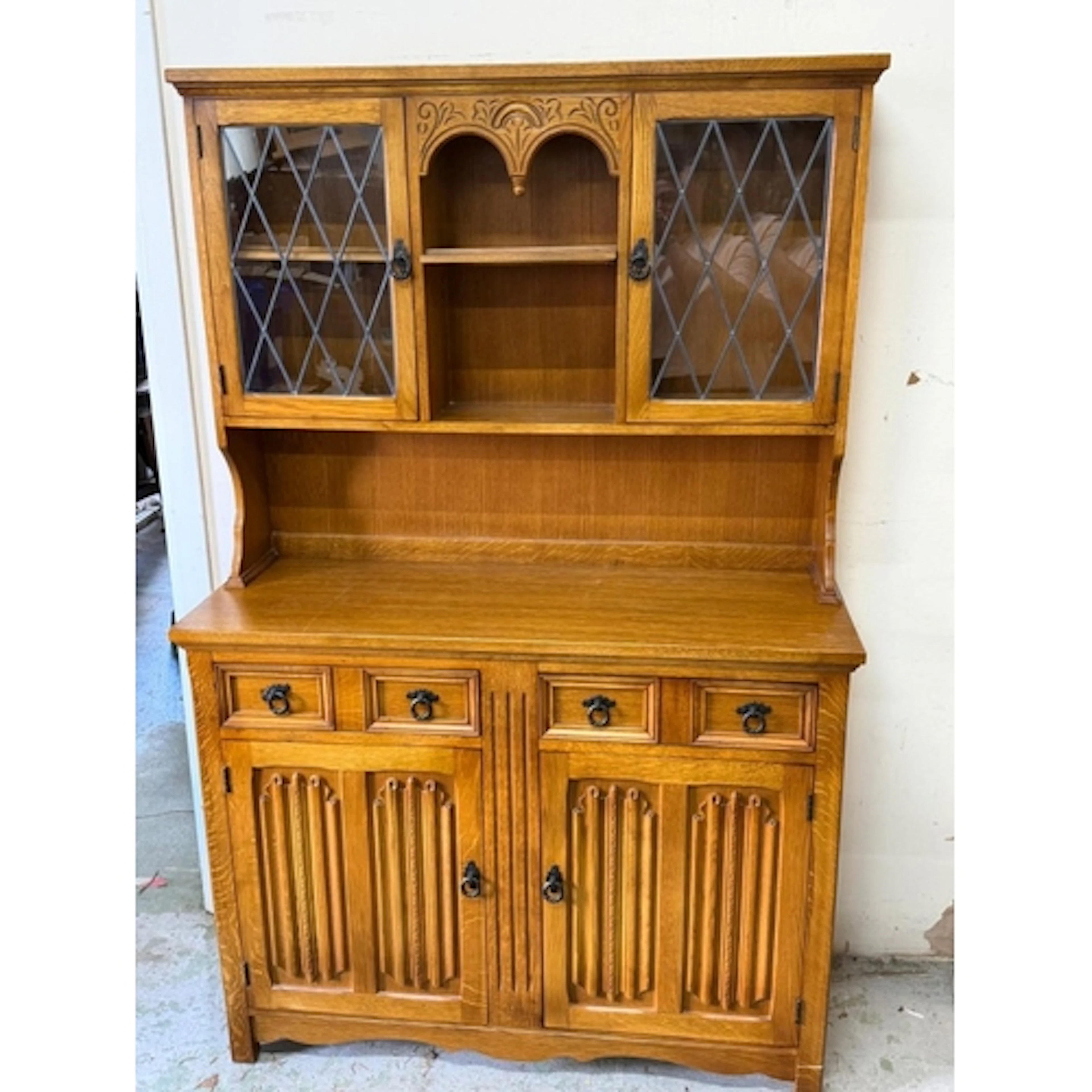 An arts and crafts style dresser with lead glass display wit...