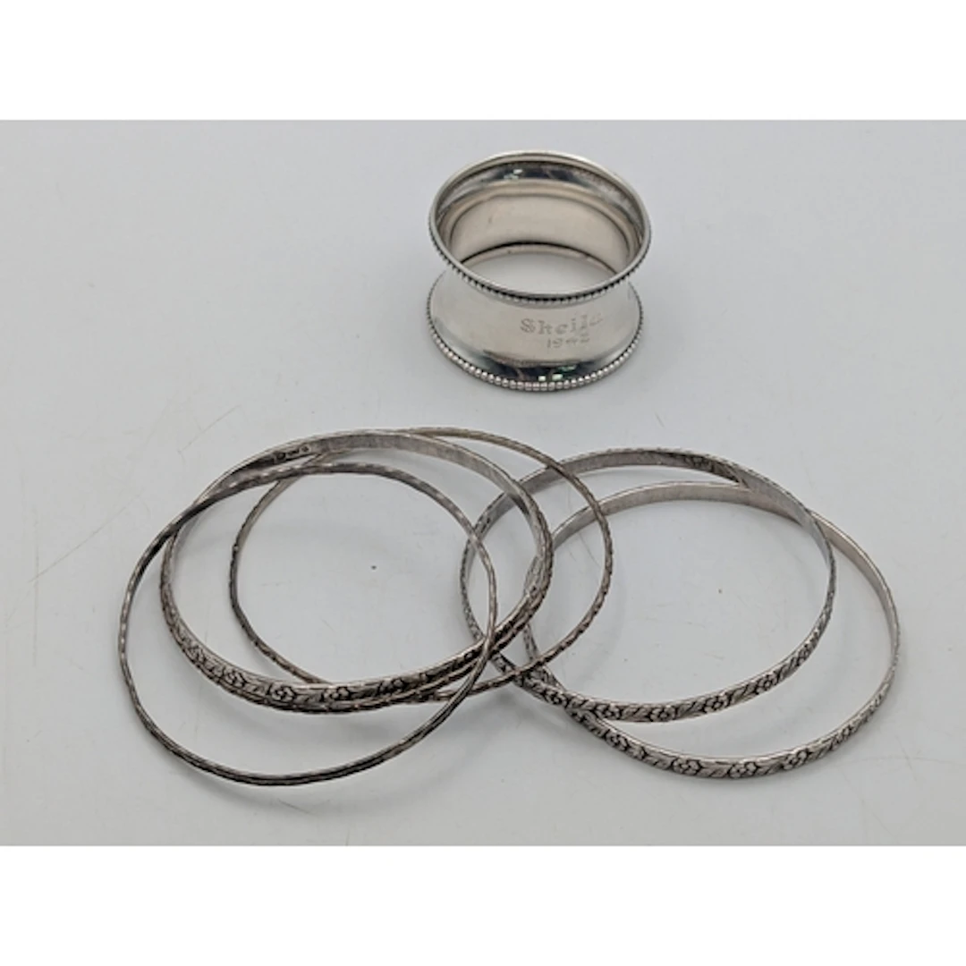 Six silver bangles, three having floral decoration, together...