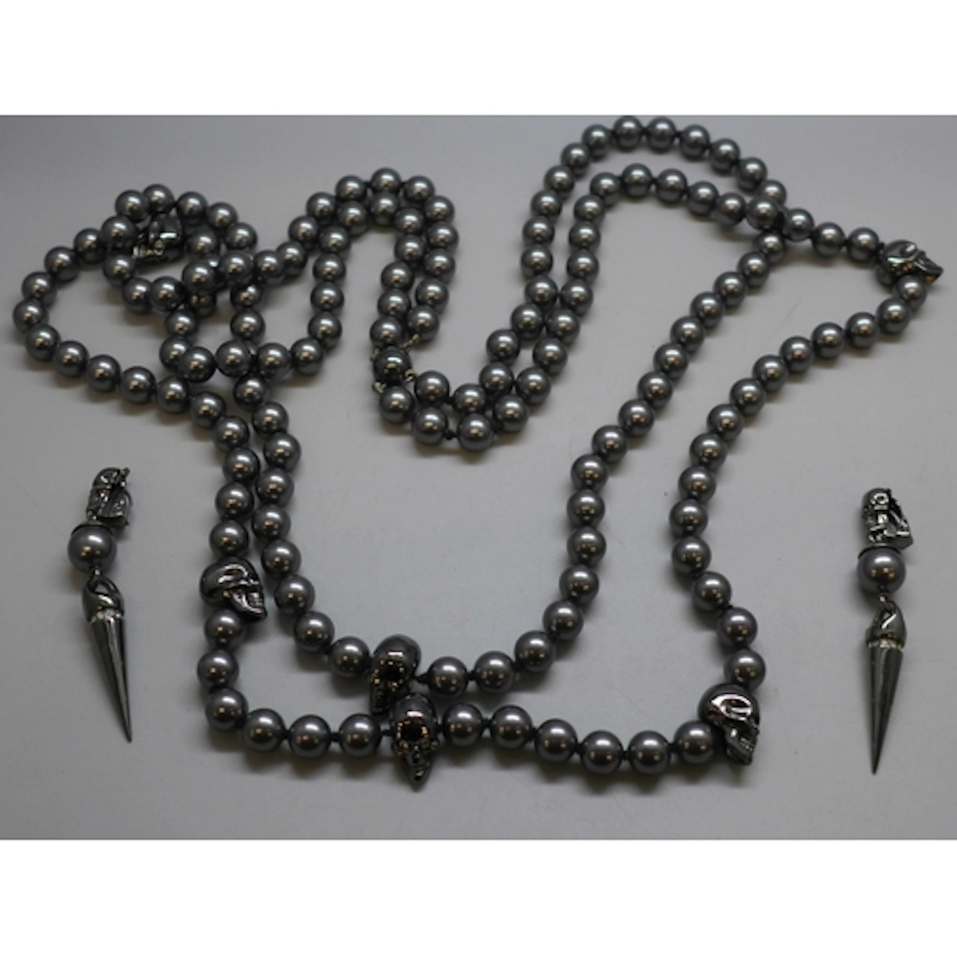 A skull design necklace and a pair of similar earrings, in t...