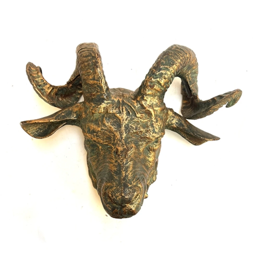 A large bronzed cast iron ram's mask, 46cm wide