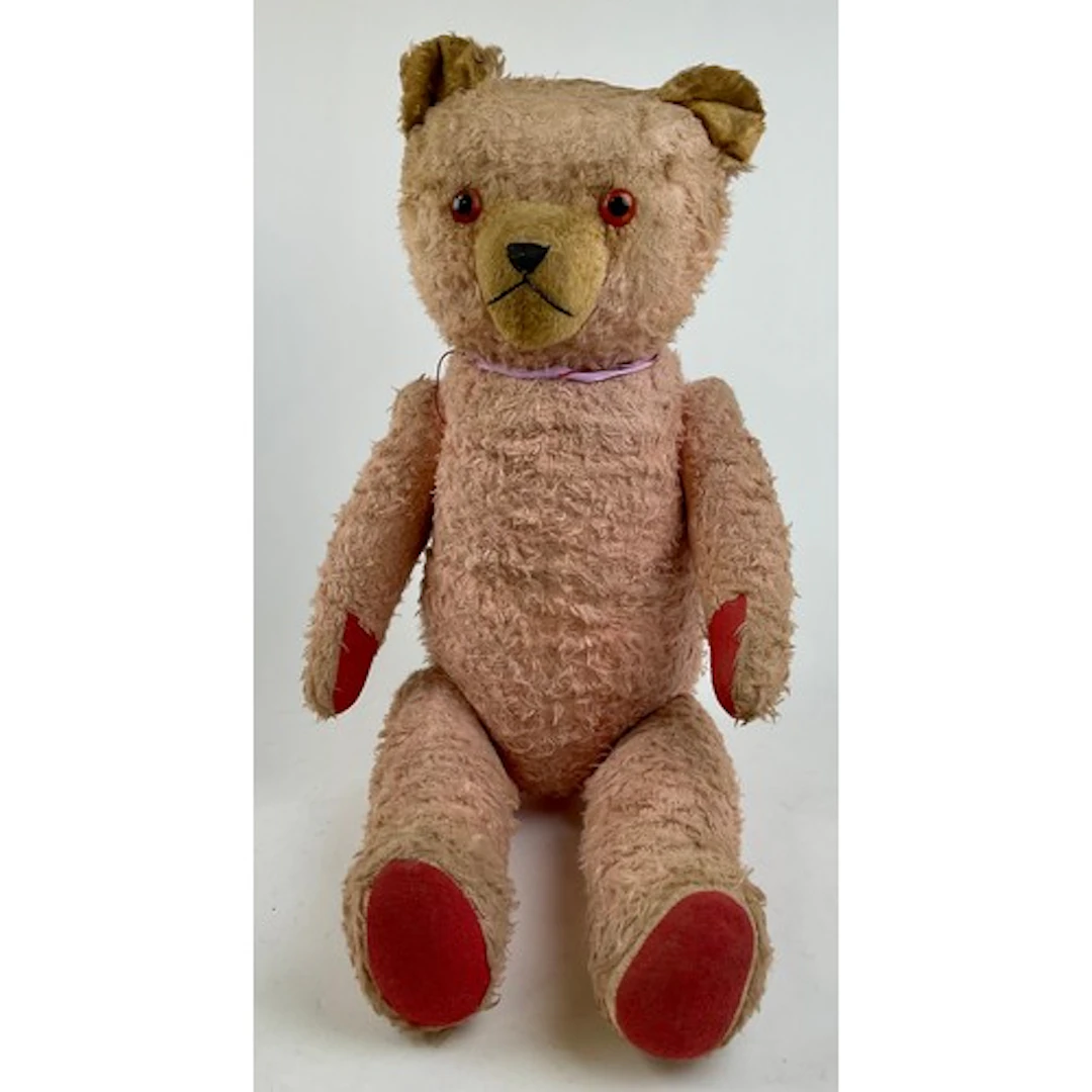 A large early 20th century pink mohair Teddy bear, amber eye...