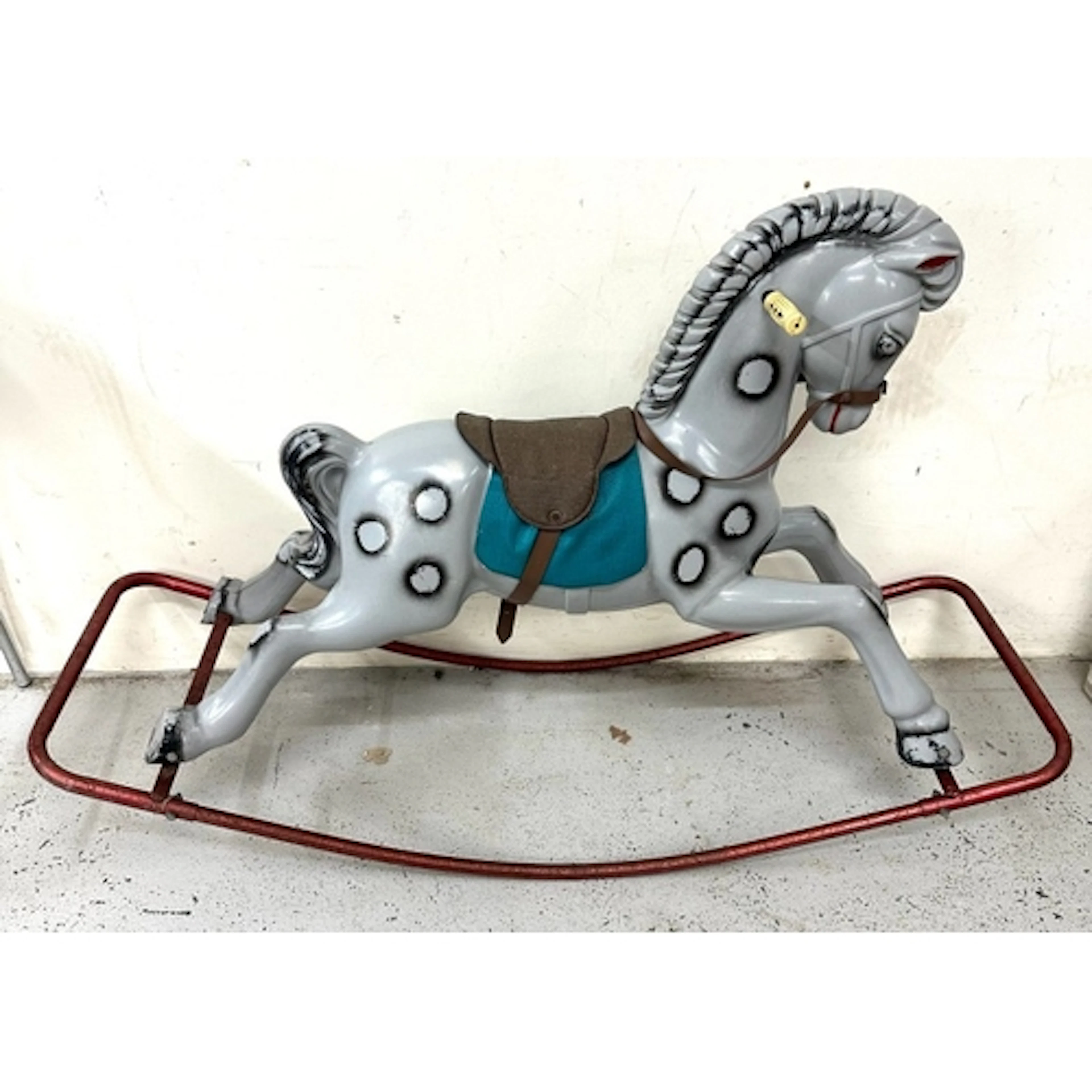 A vintage rocking horse on a red steel frame playworn, fade...