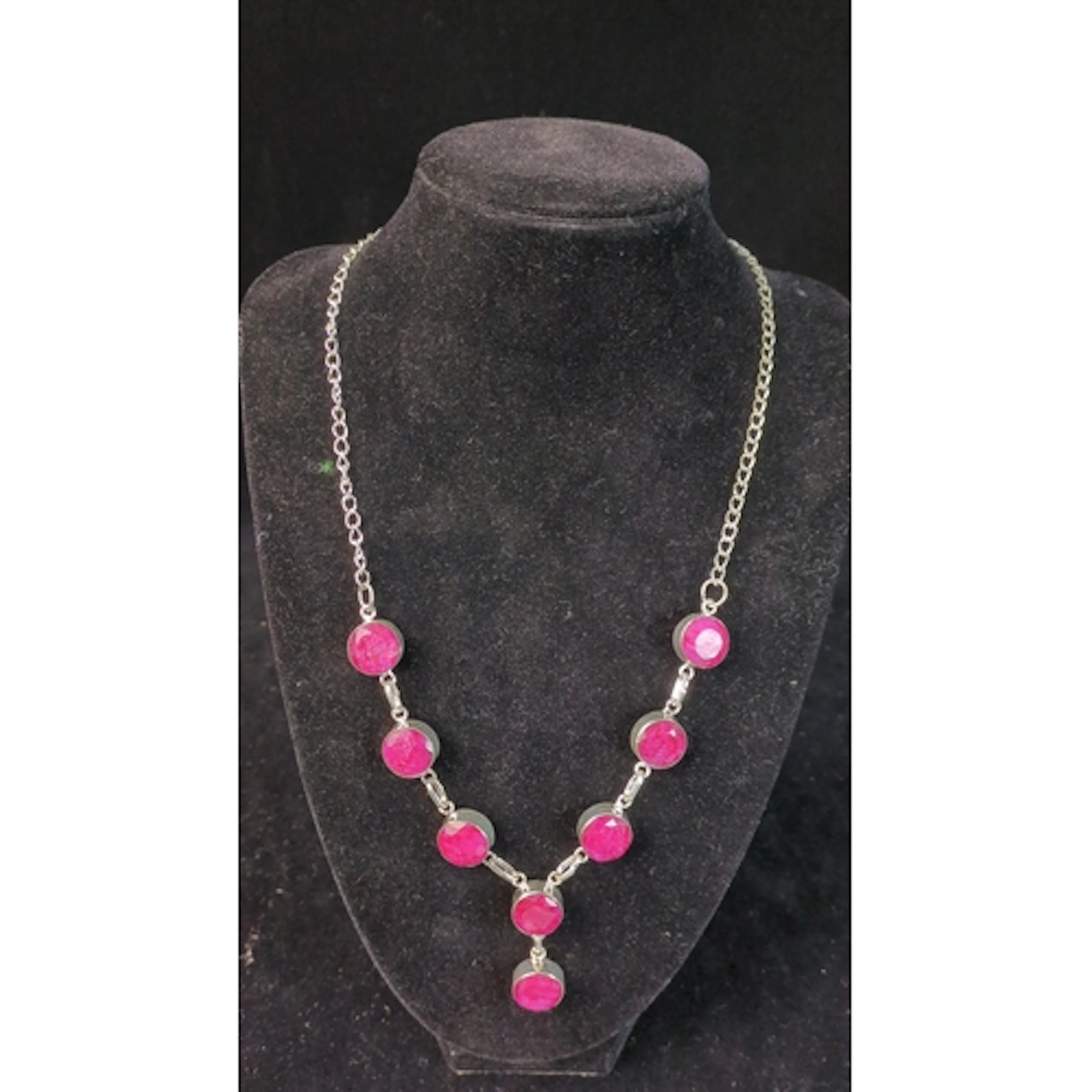 Silver necklace set with round, bezel-mounted pink stones, l...