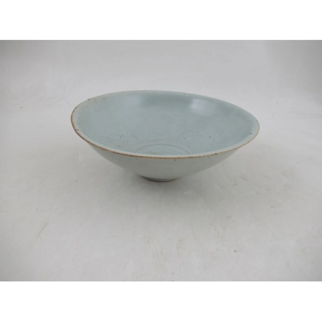 A shallow Song style celadon bowl, decorated with fish, dime...