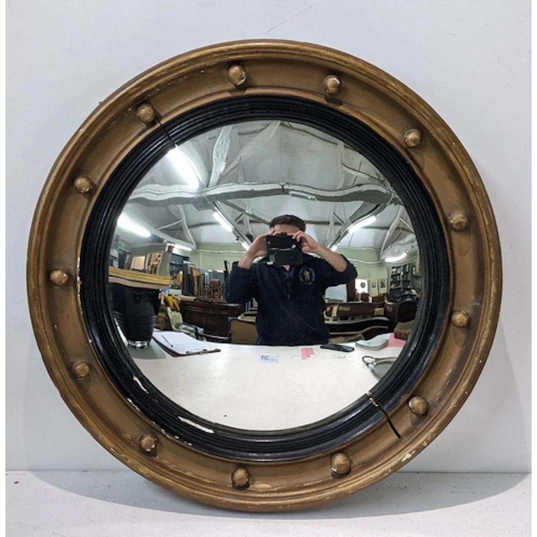 A 19th century giltwood convex butlers mirror having applied...