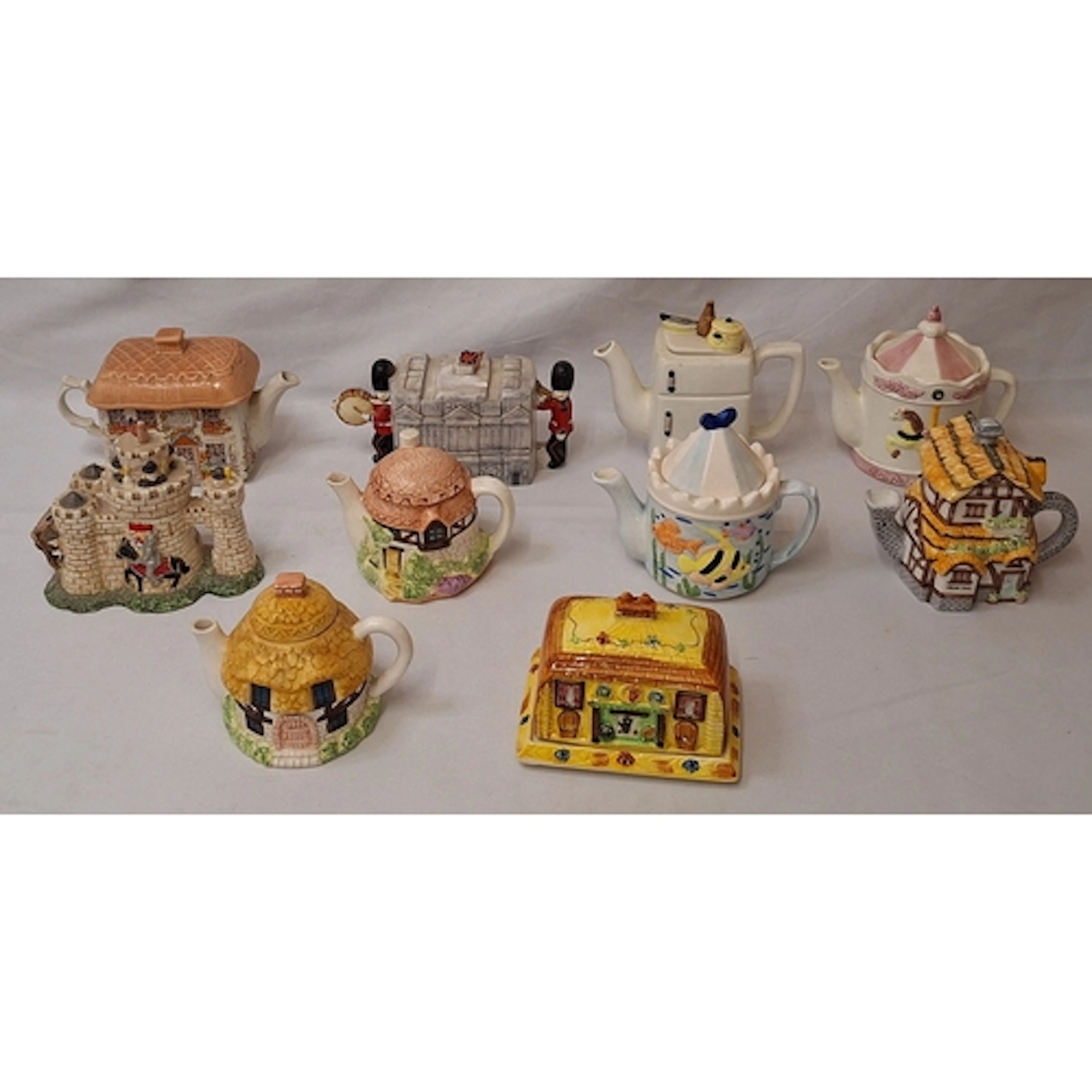 Novelty teapots, some in the form of cottages, underwater sc...