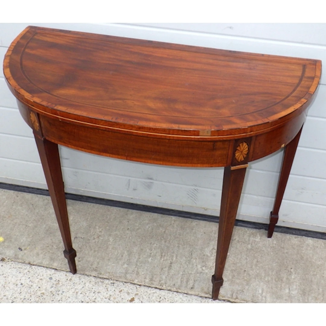 A Regency mahogany D shaped card table on tapering legs, som...