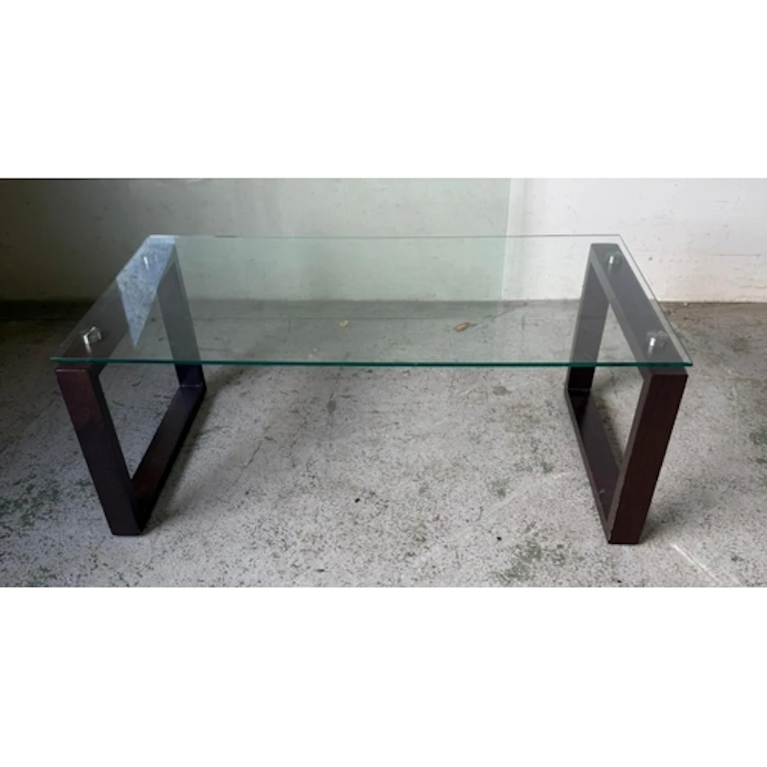 A contemporary glass topped coffee table on square dark wood...