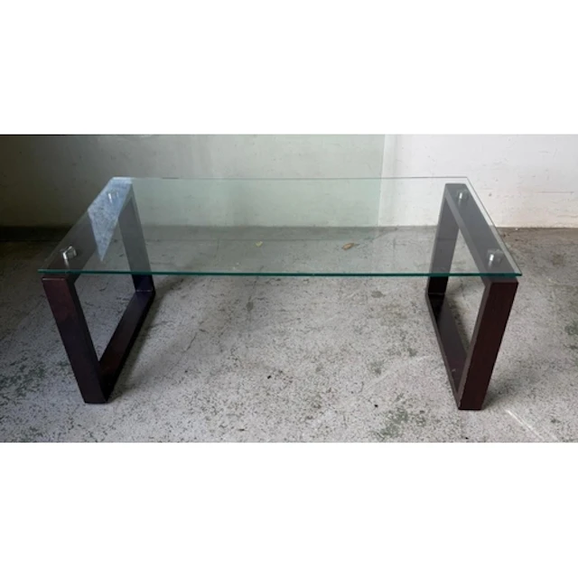 A contemporary glass topped coffee table on square dark wood...