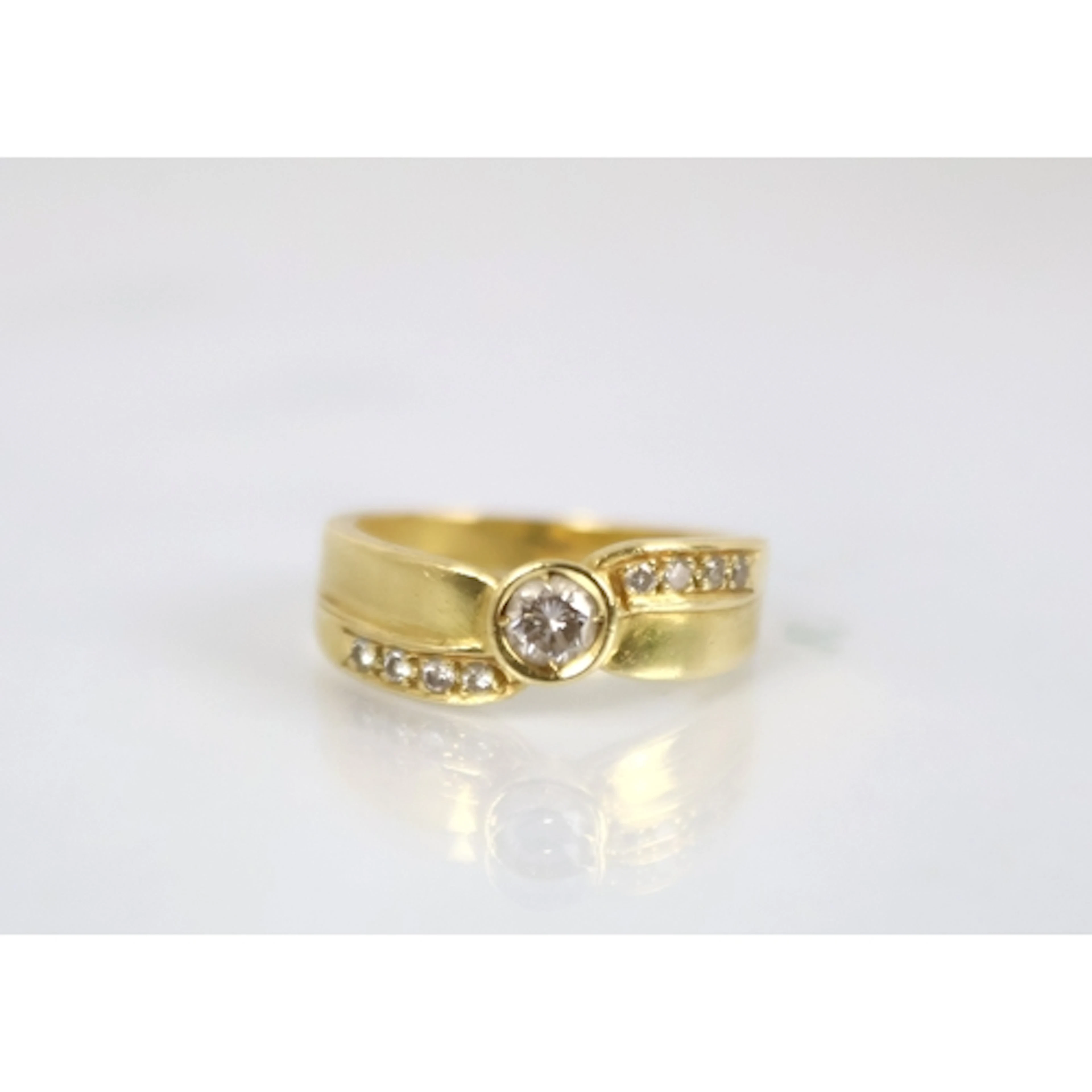 A contemporary diamond dress ring, the central solitaire di...