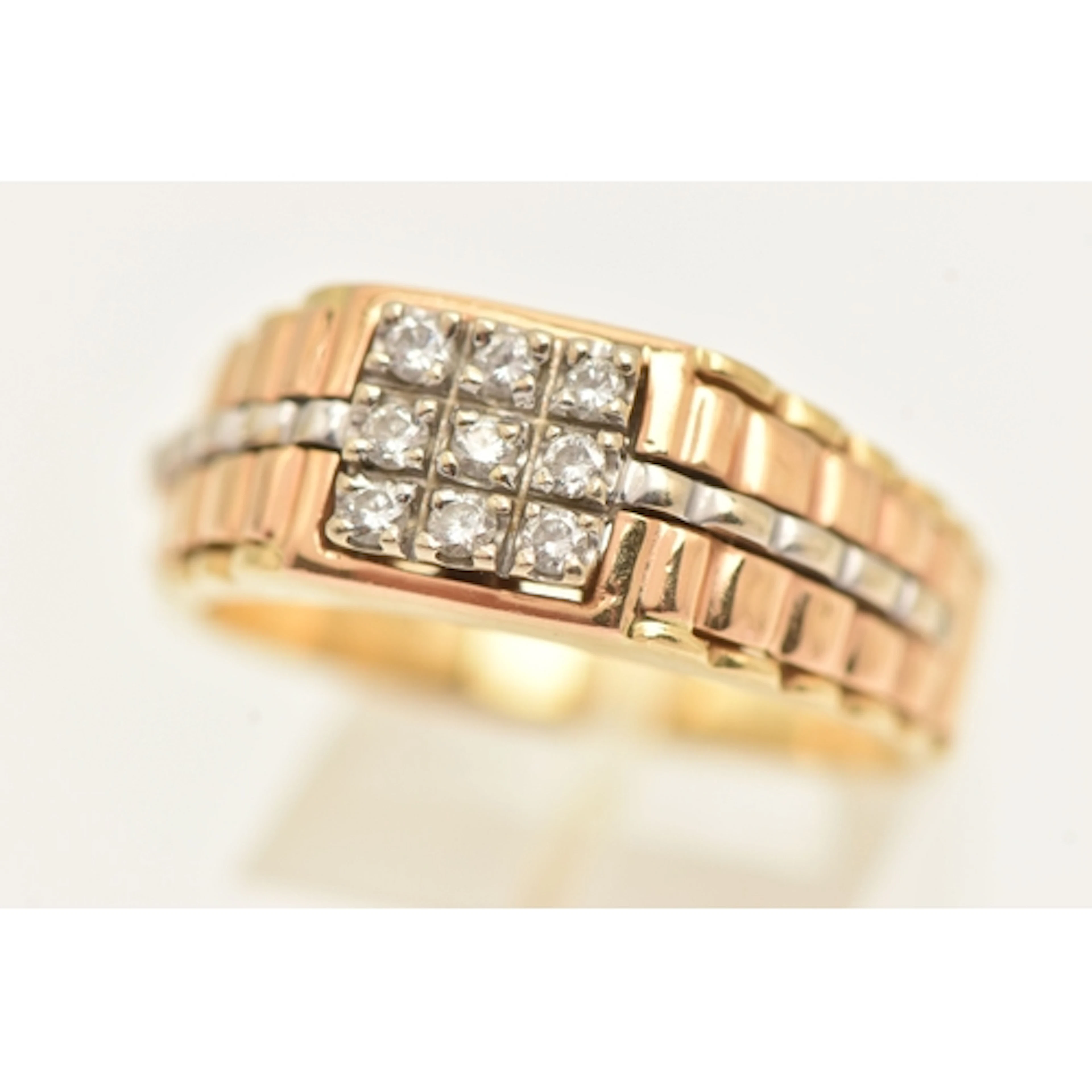 A ROLEX STYLE RING, bi colour ring set with nine round brill...