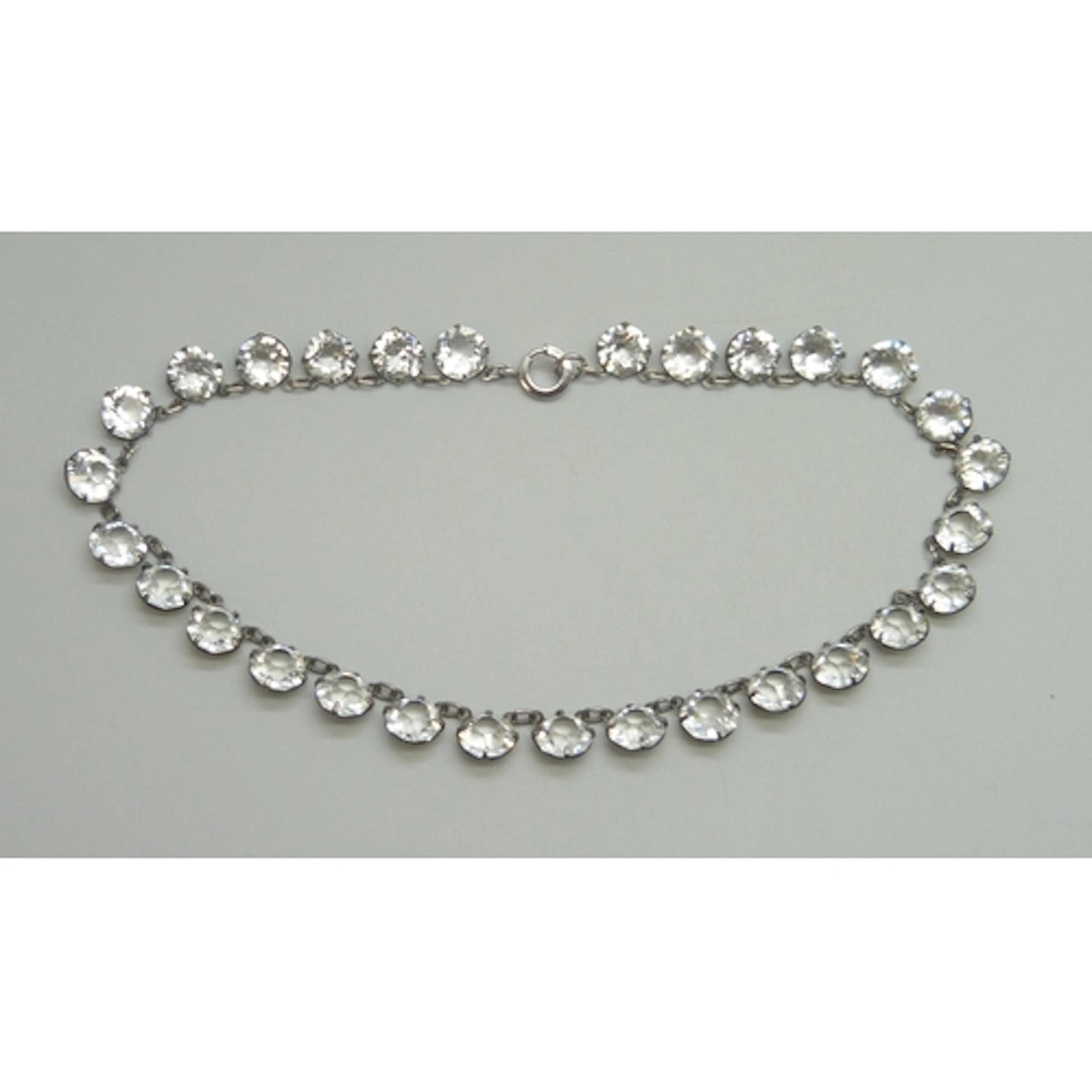 A white metal Art Deco riviere necklace set with rock crysta...