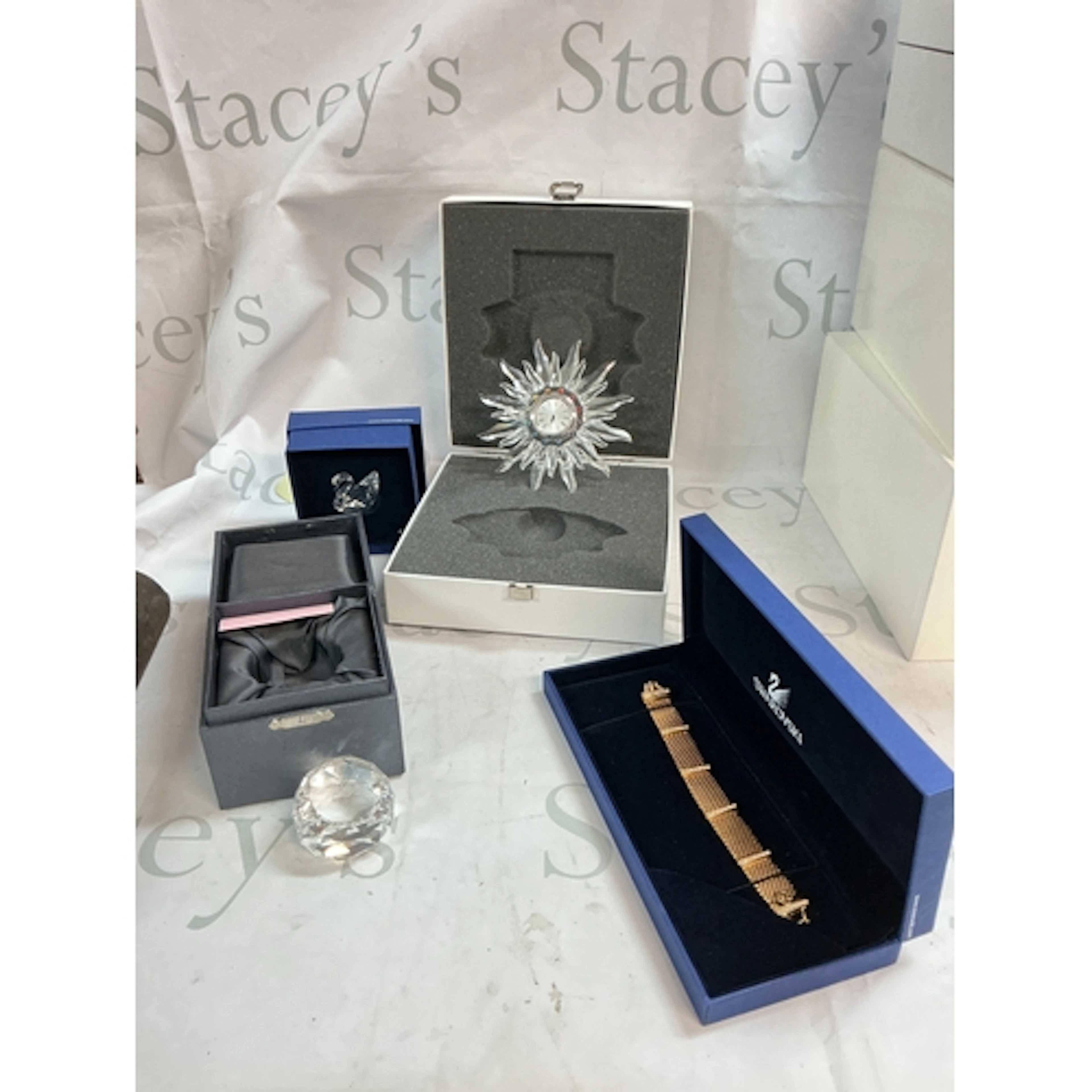 A collection of a Swarovski clock, bracelet, swan, and a Hon...