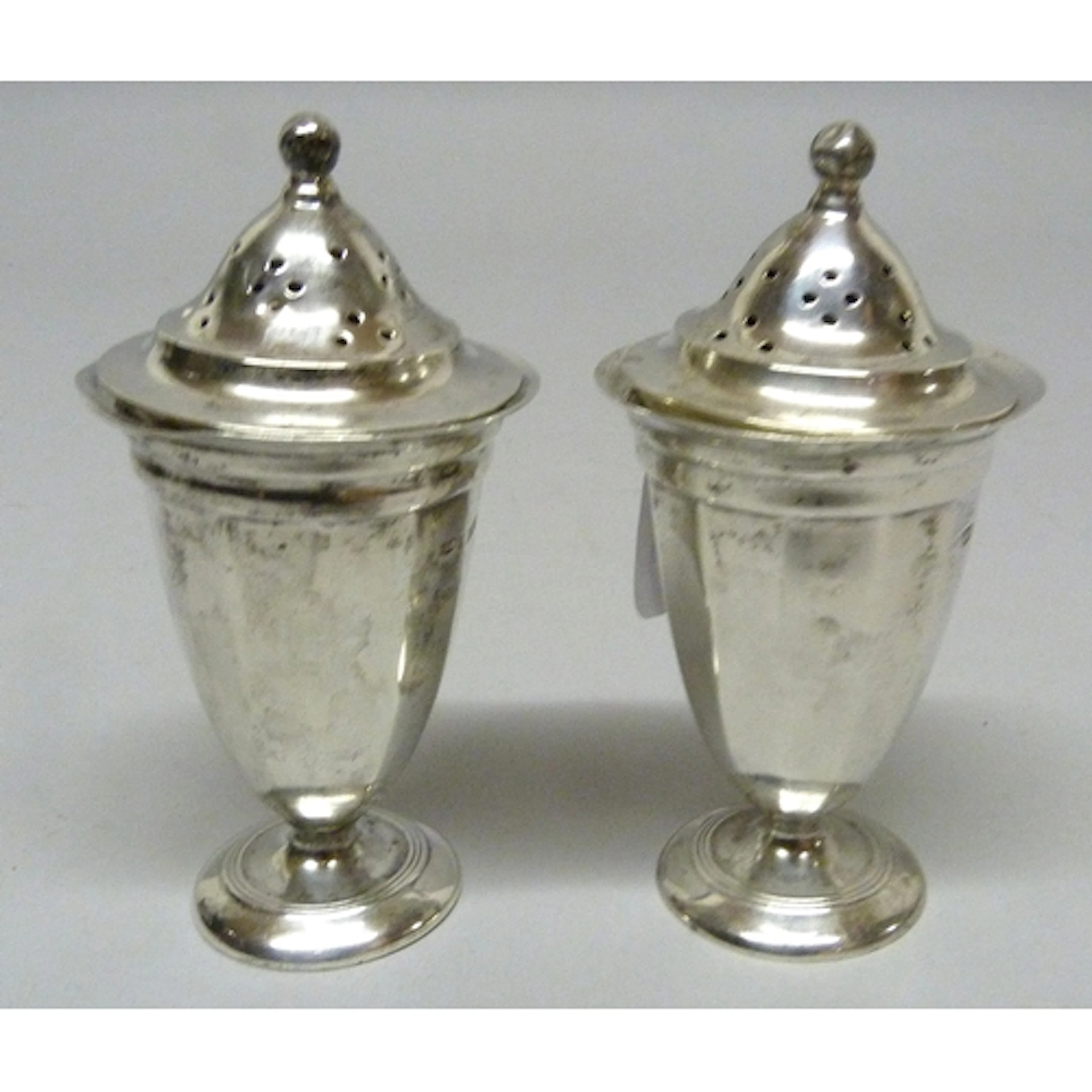 Pair of George V silver domed shaped pepper pots with covers...