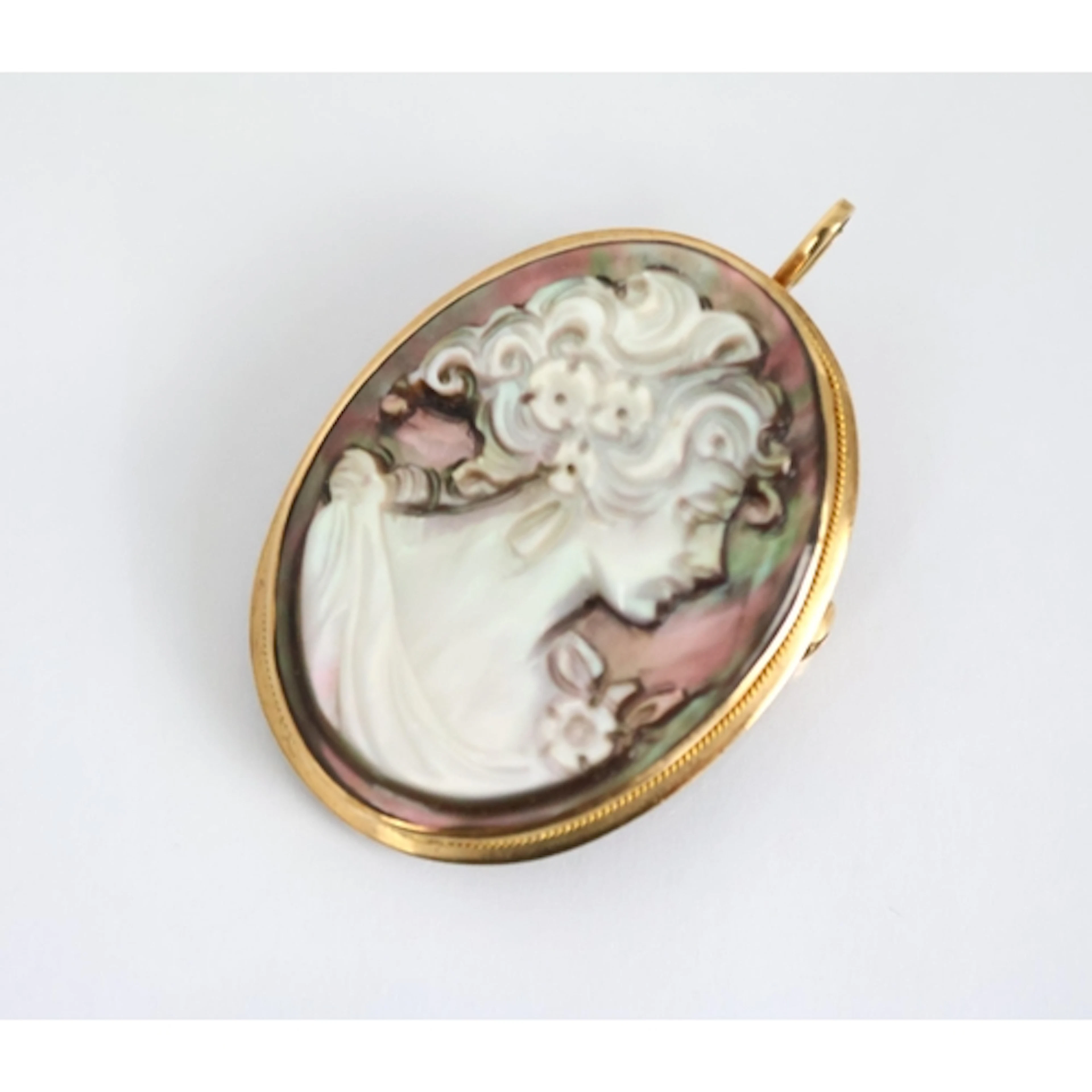 A carved shell cameo pendant or brooch, the oval panel depic...