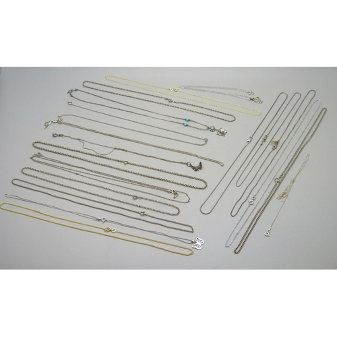 A collection of silver, silver gilt and white metal necklace...