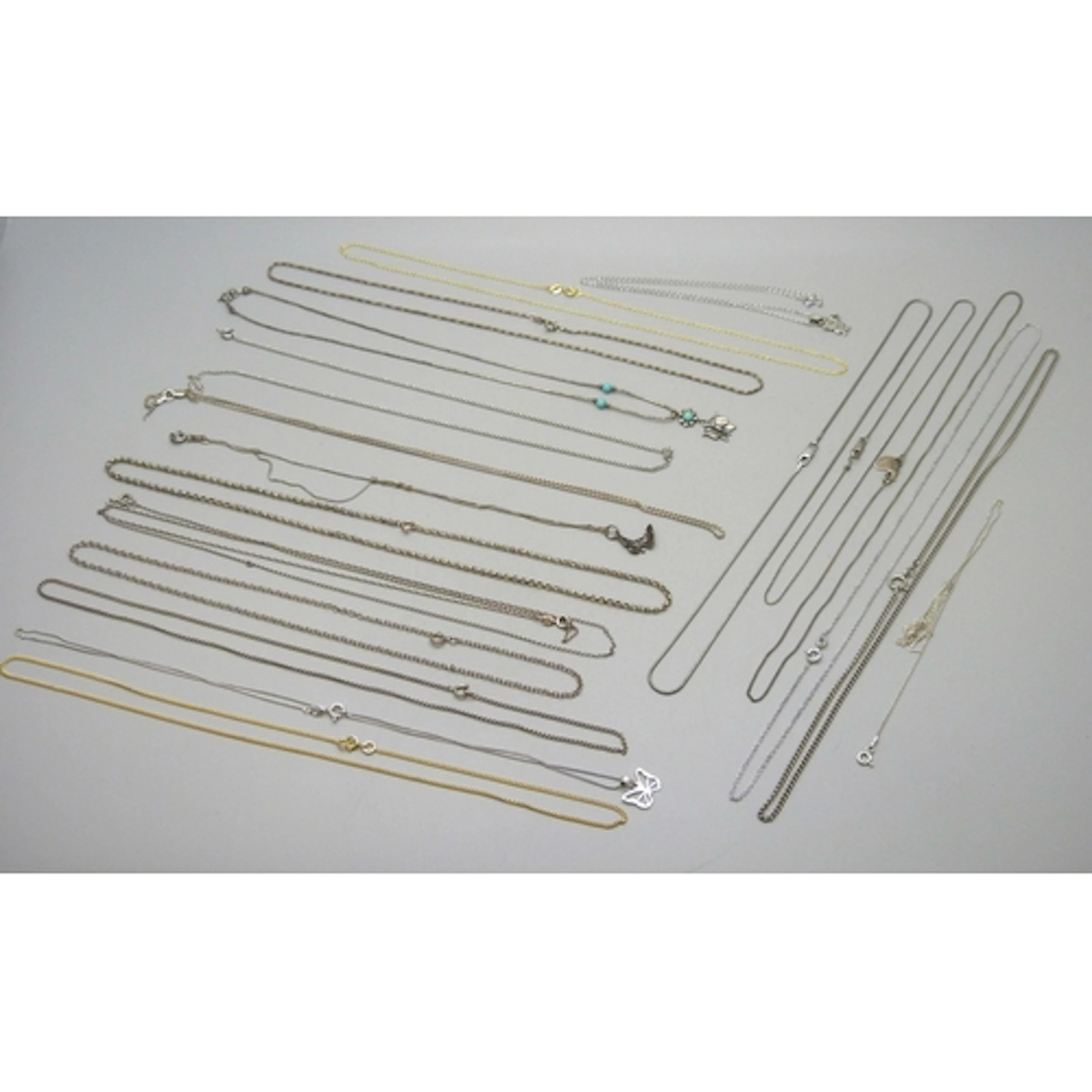 A collection of silver, silver gilt and white metal necklace...