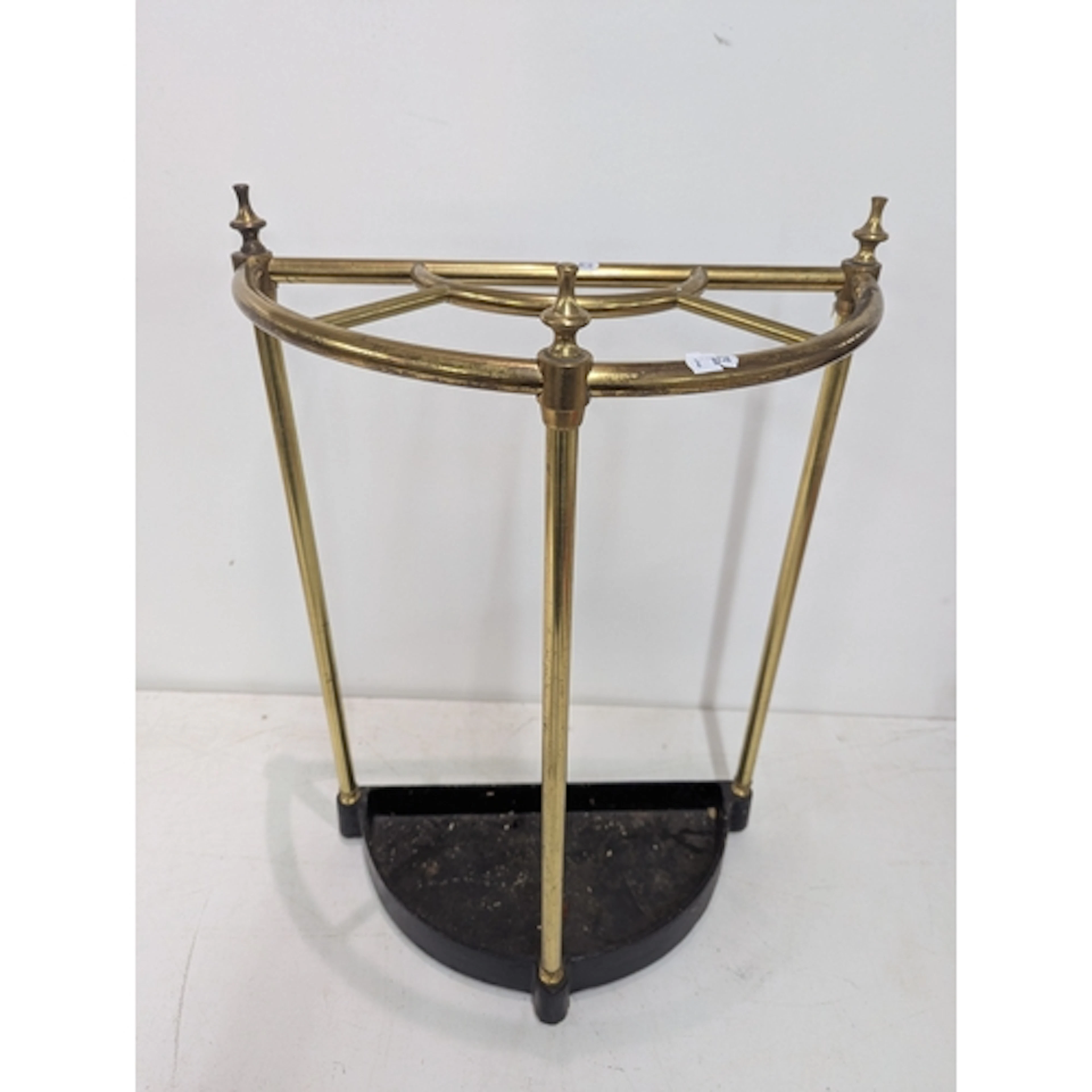 A demi-lune brass and cast-iron umbrella/walking stick stand...