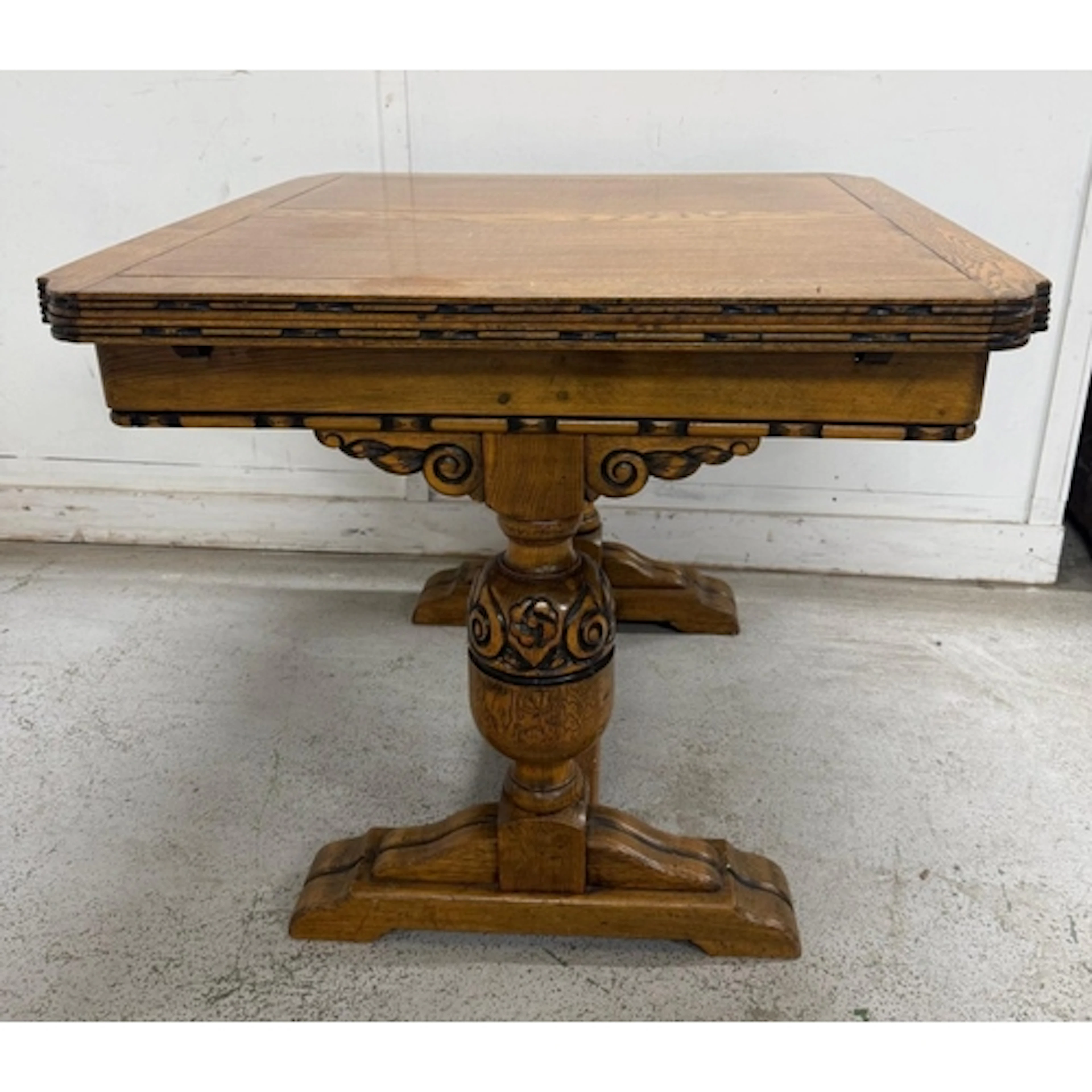 An oak art deco style extendable dining table on carved balu...