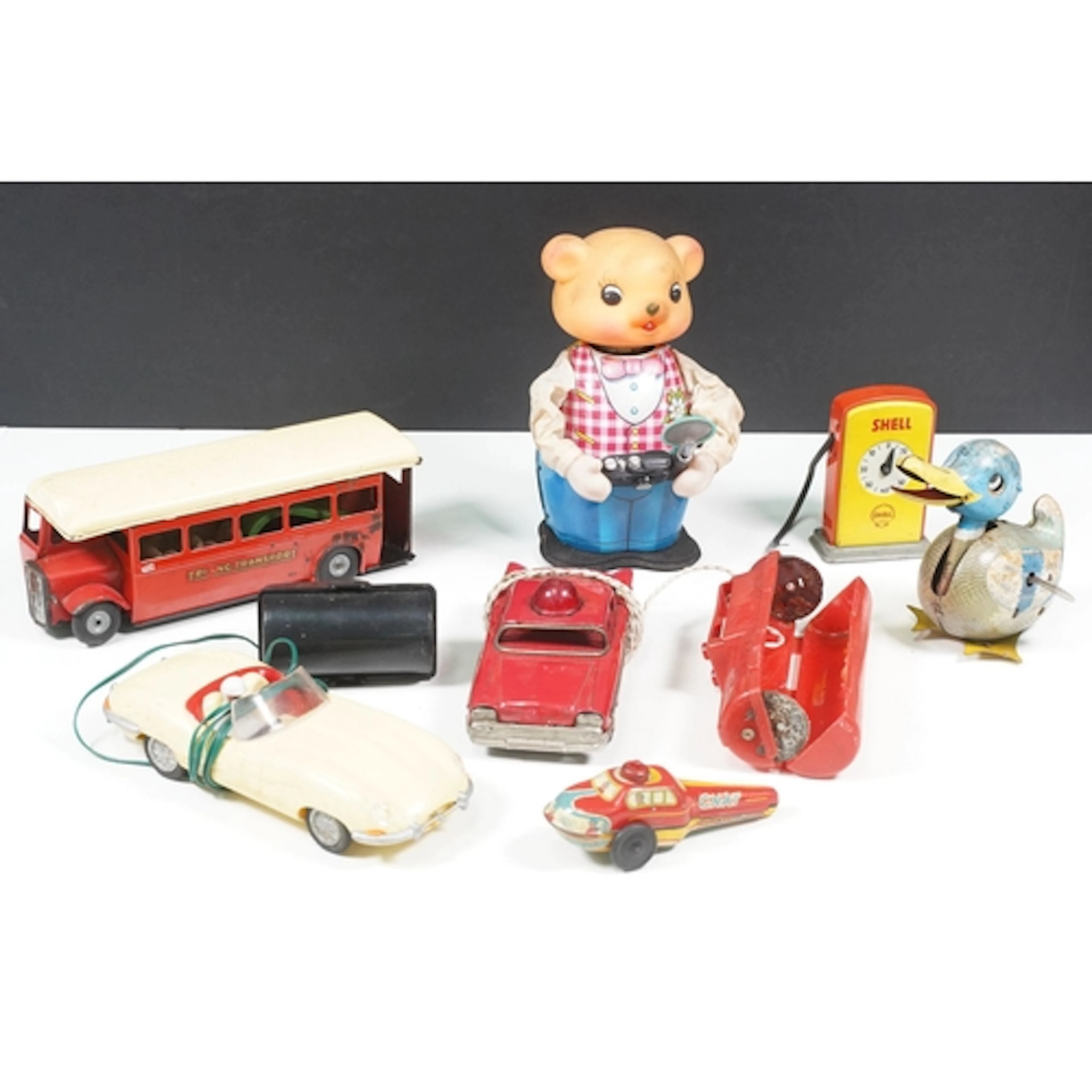 Seven mid 20th C toys to include Triang tin plate bus, plast...