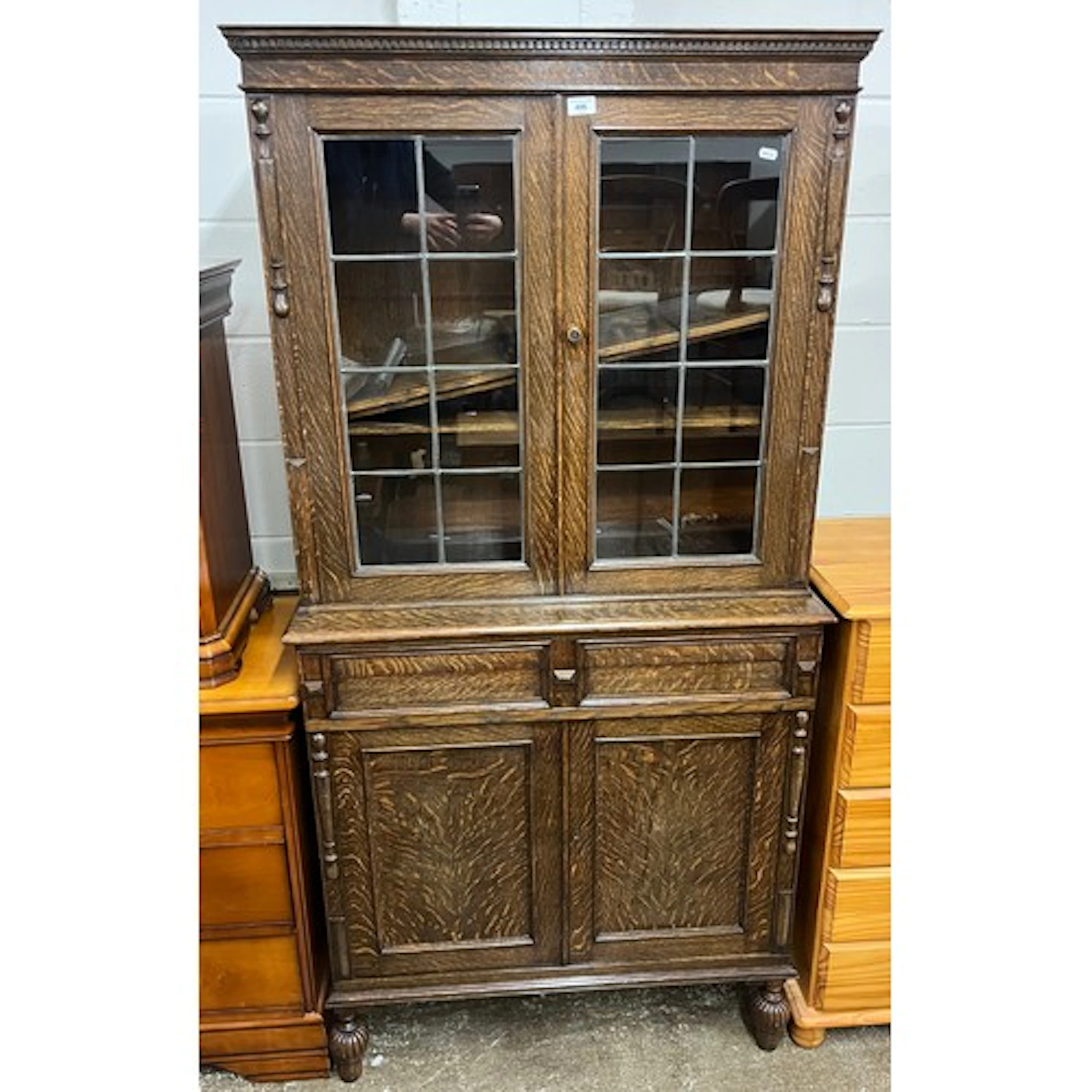 Carved oak cabinet bookcase, the upper section enclosed by p...