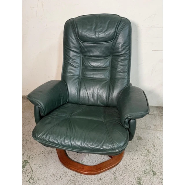 A dark green leather stressless style recliner