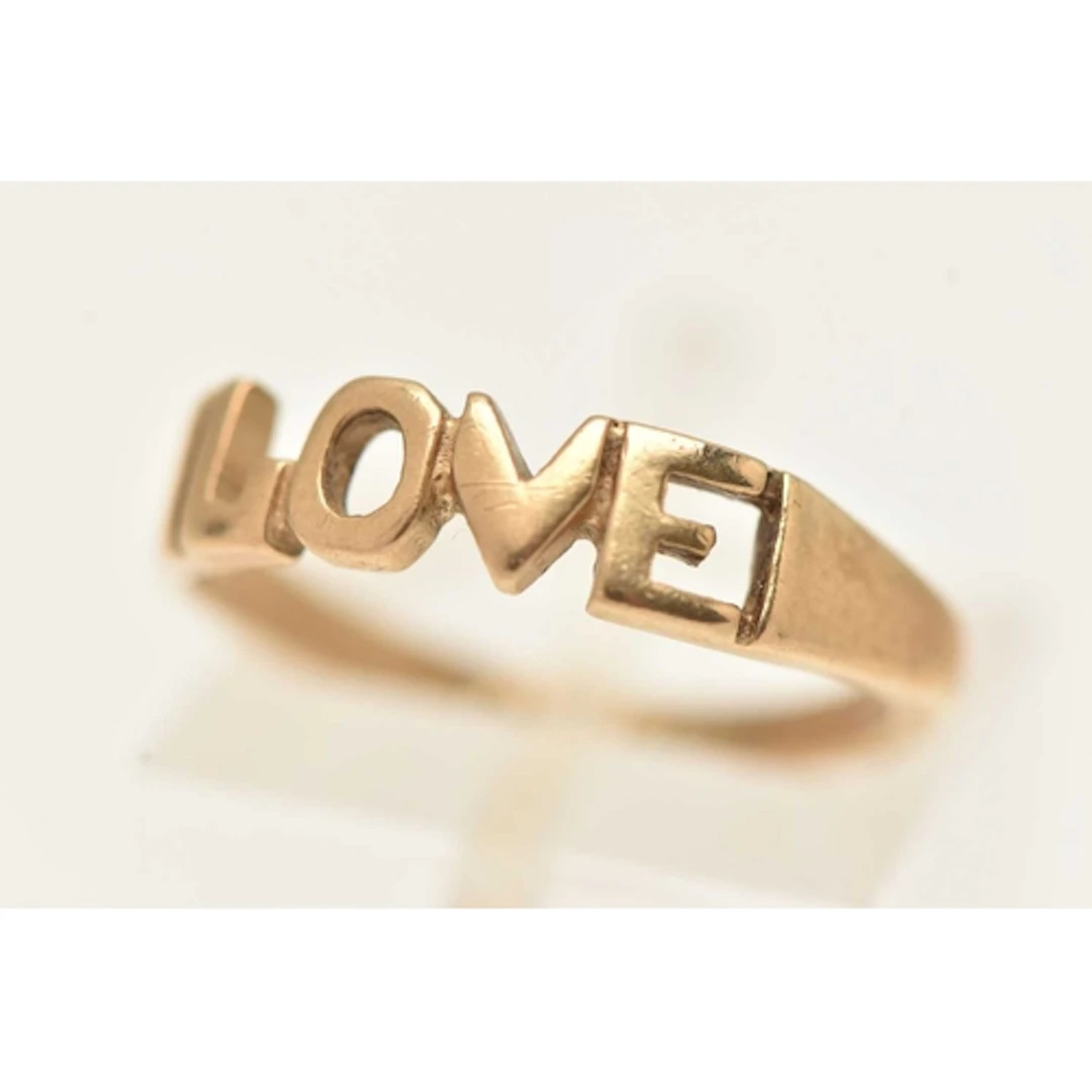 A 9CT GOLD RING, open work 'LOVE' inscription, to a polished...