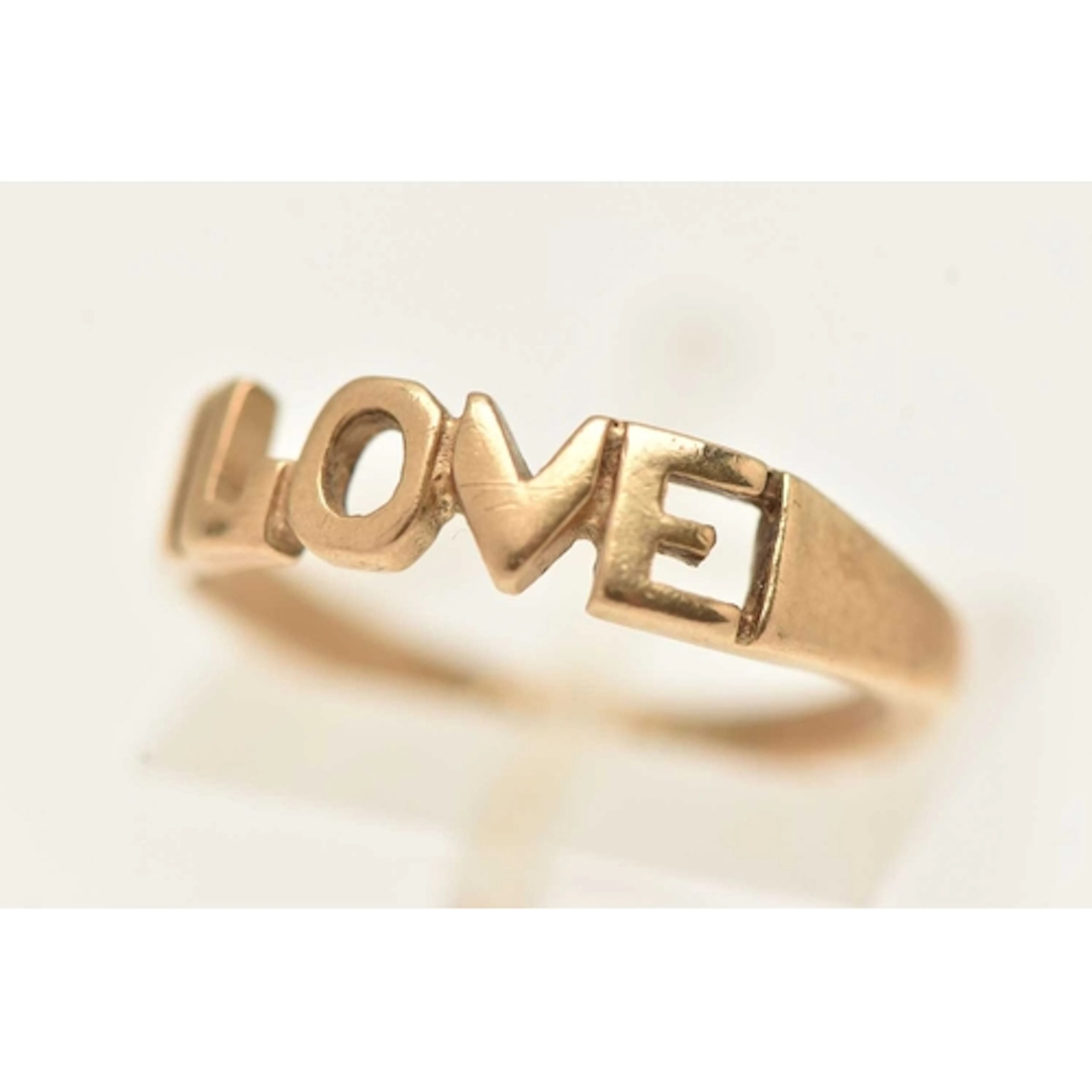 A 9CT GOLD RING, open work 'LOVE' inscription, to a polished...