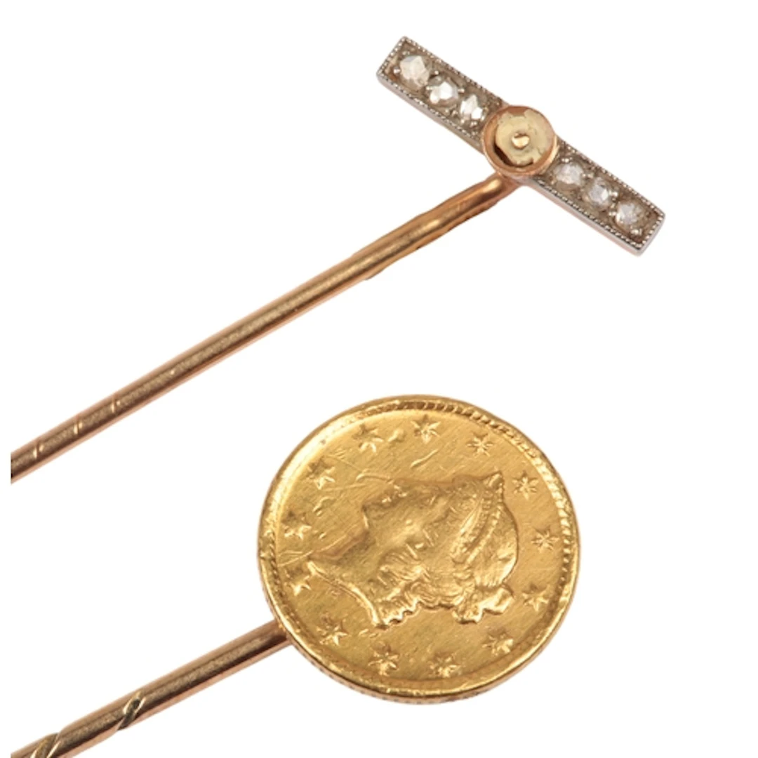 A gold coin stick pin and a diamond stick pin, early 20th ce...
