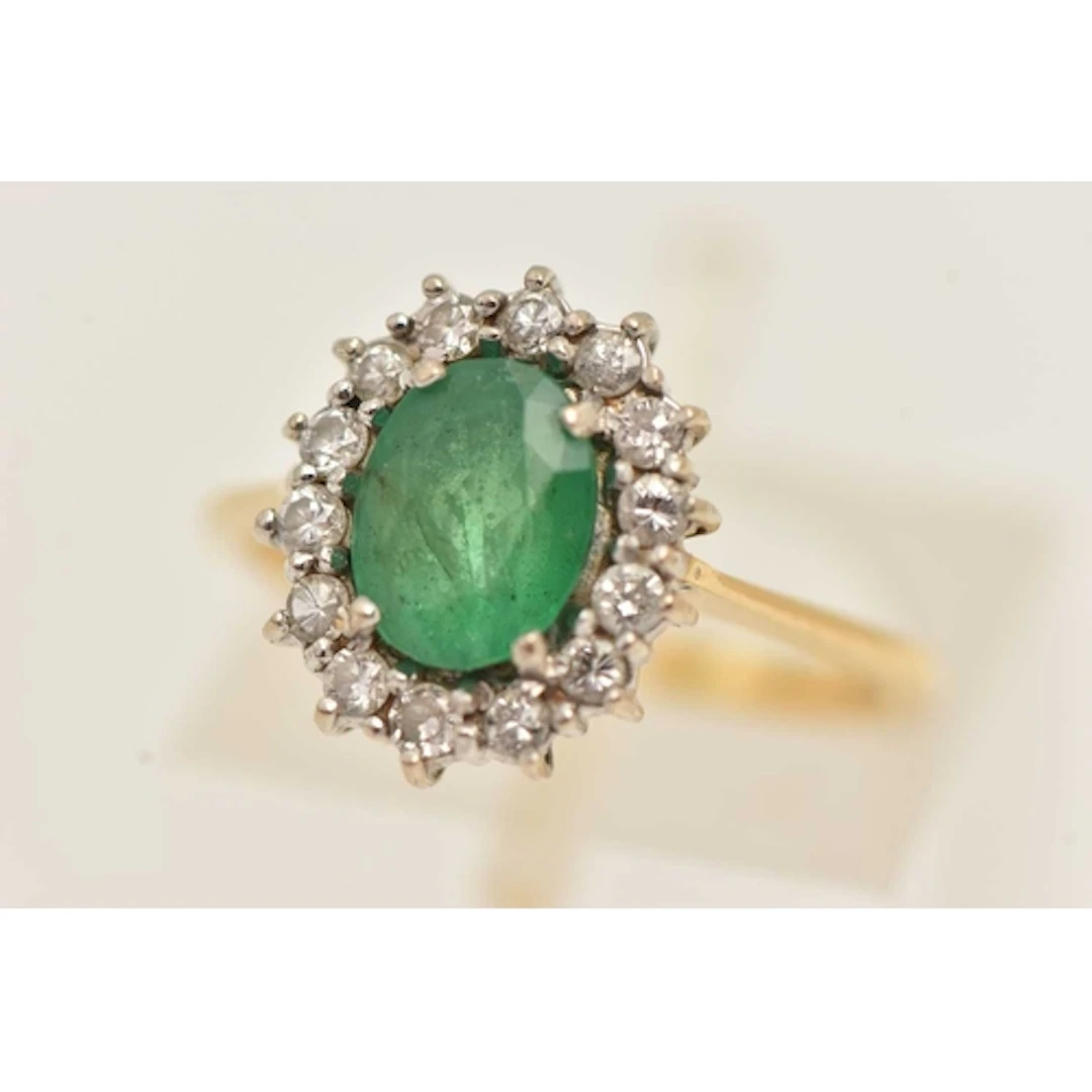 AN 18CT YELLOW GOLD EMERALD RING, an oval cut emerald, set w...