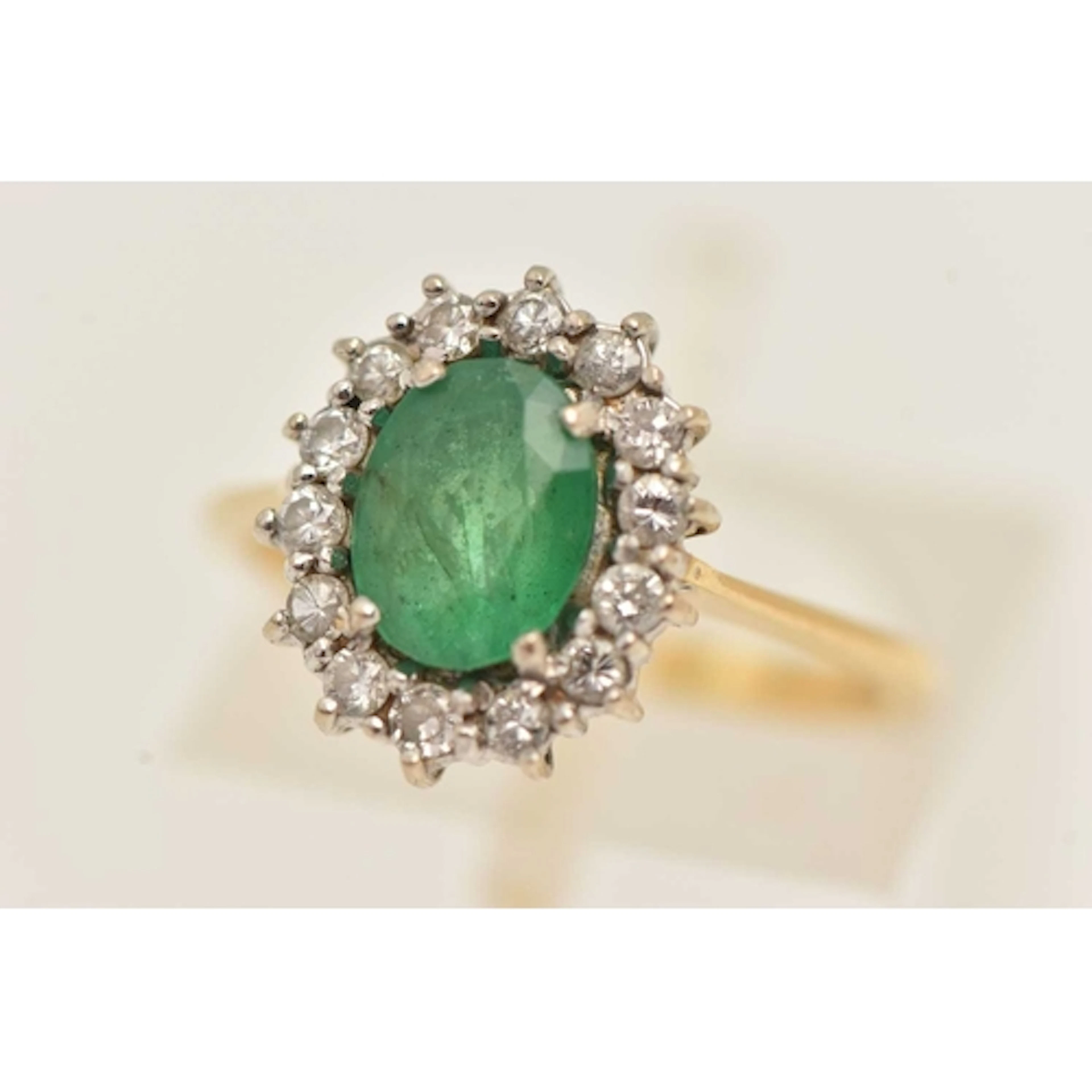 AN 18CT YELLOW GOLD EMERALD RING, an oval cut emerald, set w...