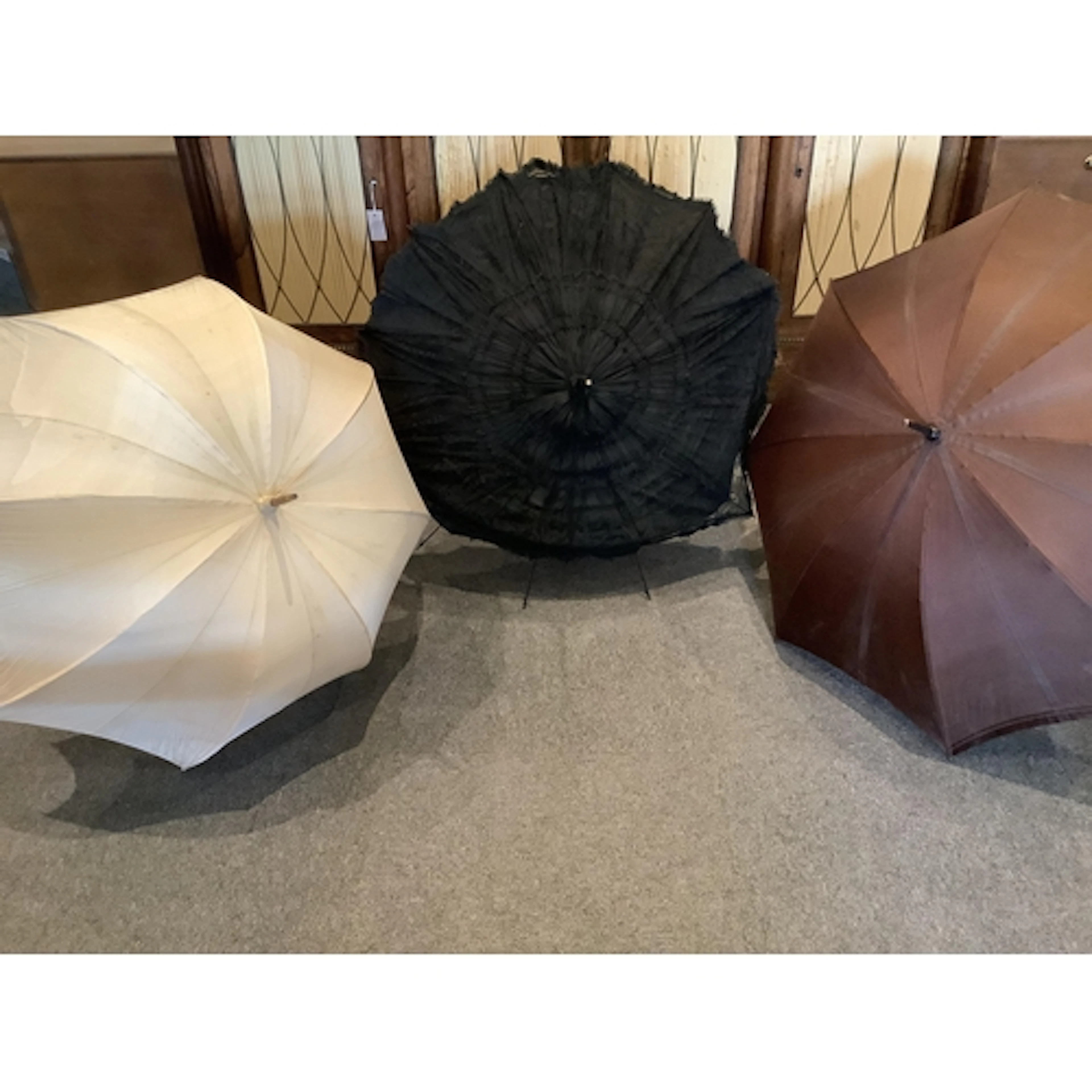 Two early 20th century umbrellas and a lace parasol unused f...