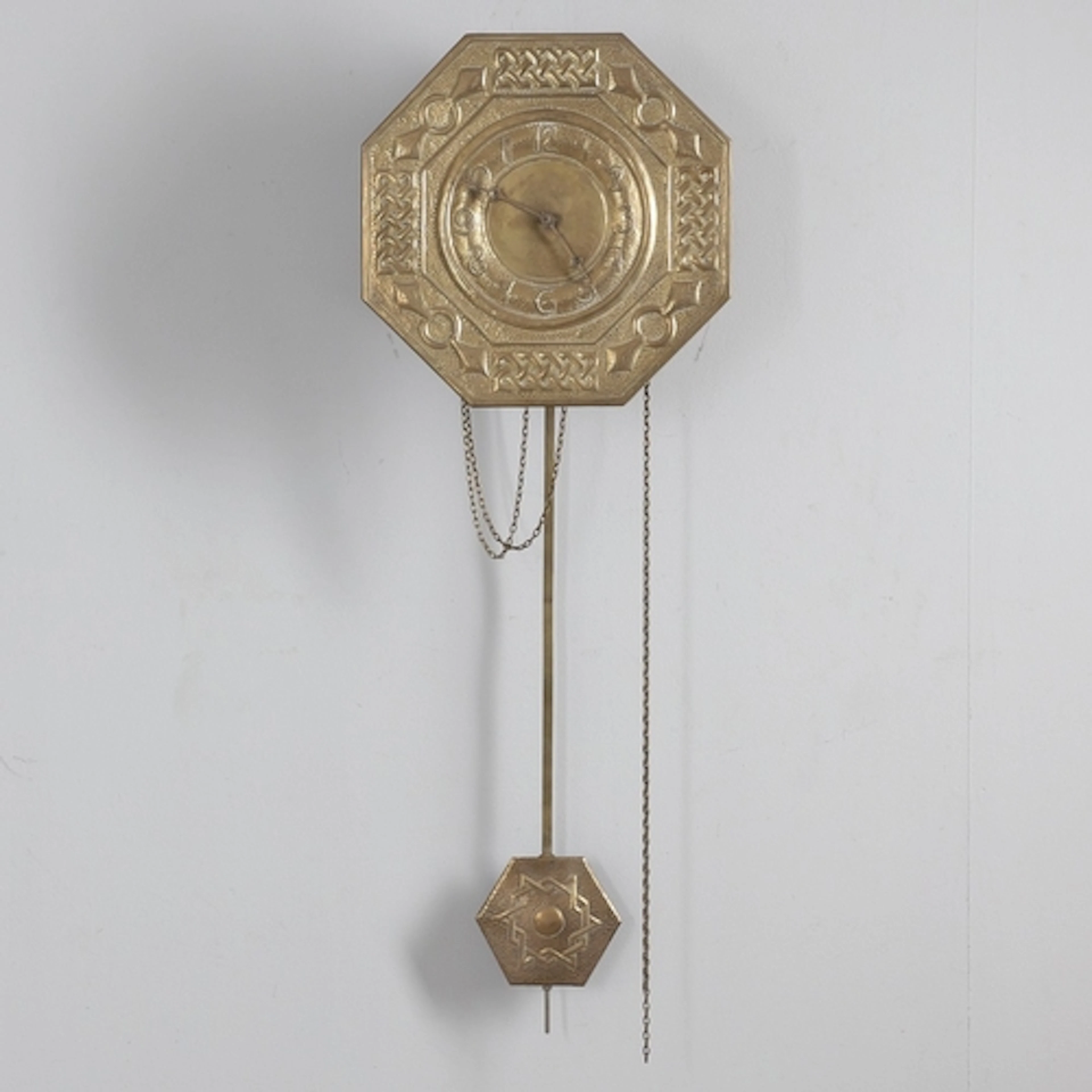 AN ARTS & CRAFTS OCTAGONAL BRASS WALL CLOCK. the brass face ...