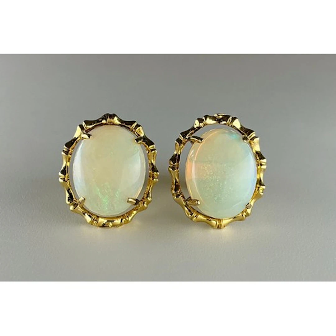 A pair of opal earrings, oval cabochon opals with orange gre...
