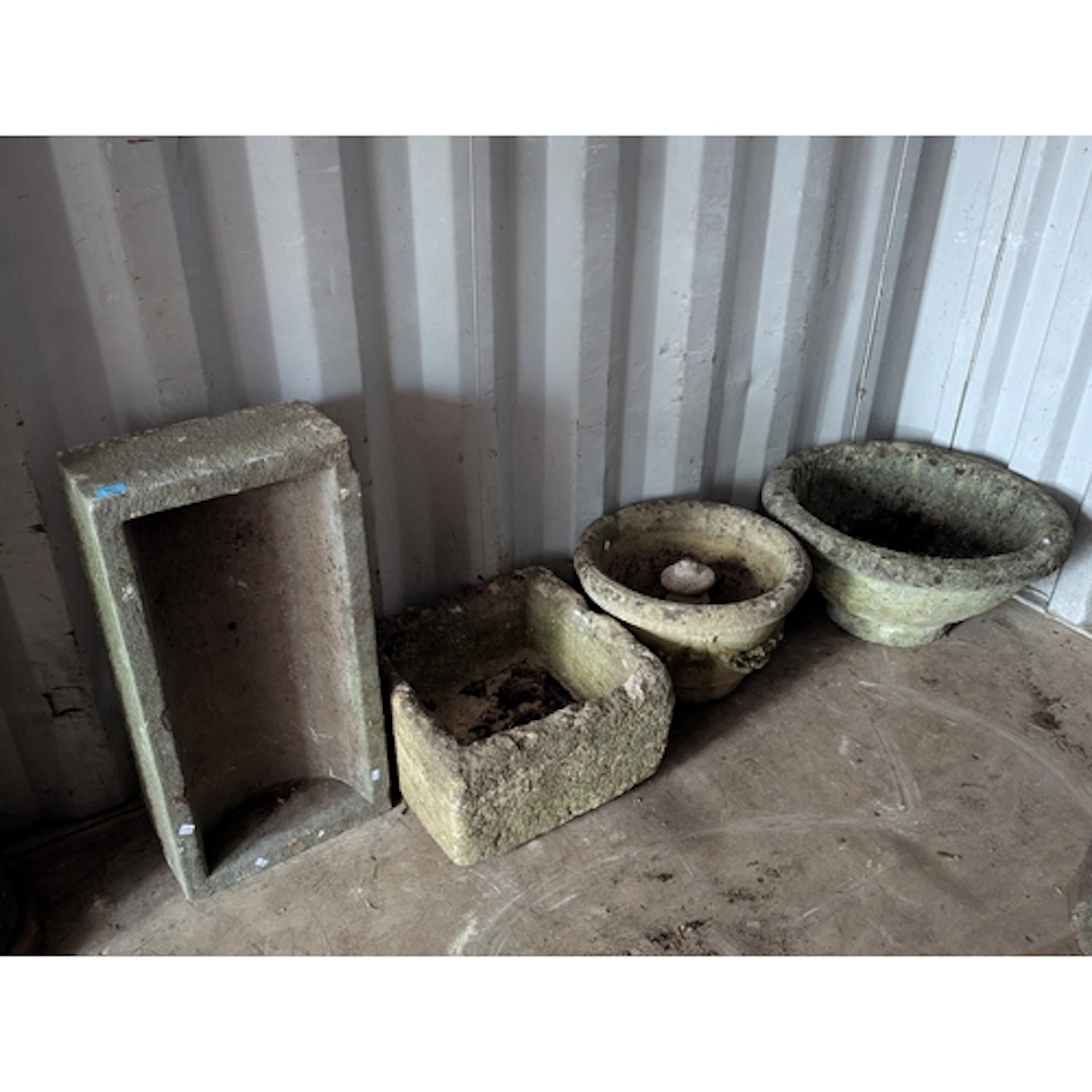 A collection of stone and composition garden planters and tr...