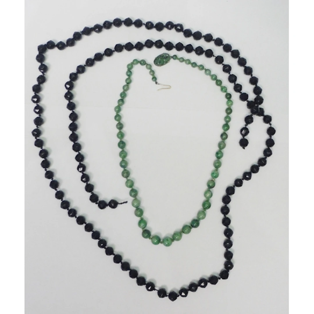 A Chinese necklace of mottled jade beads fastening with an u...