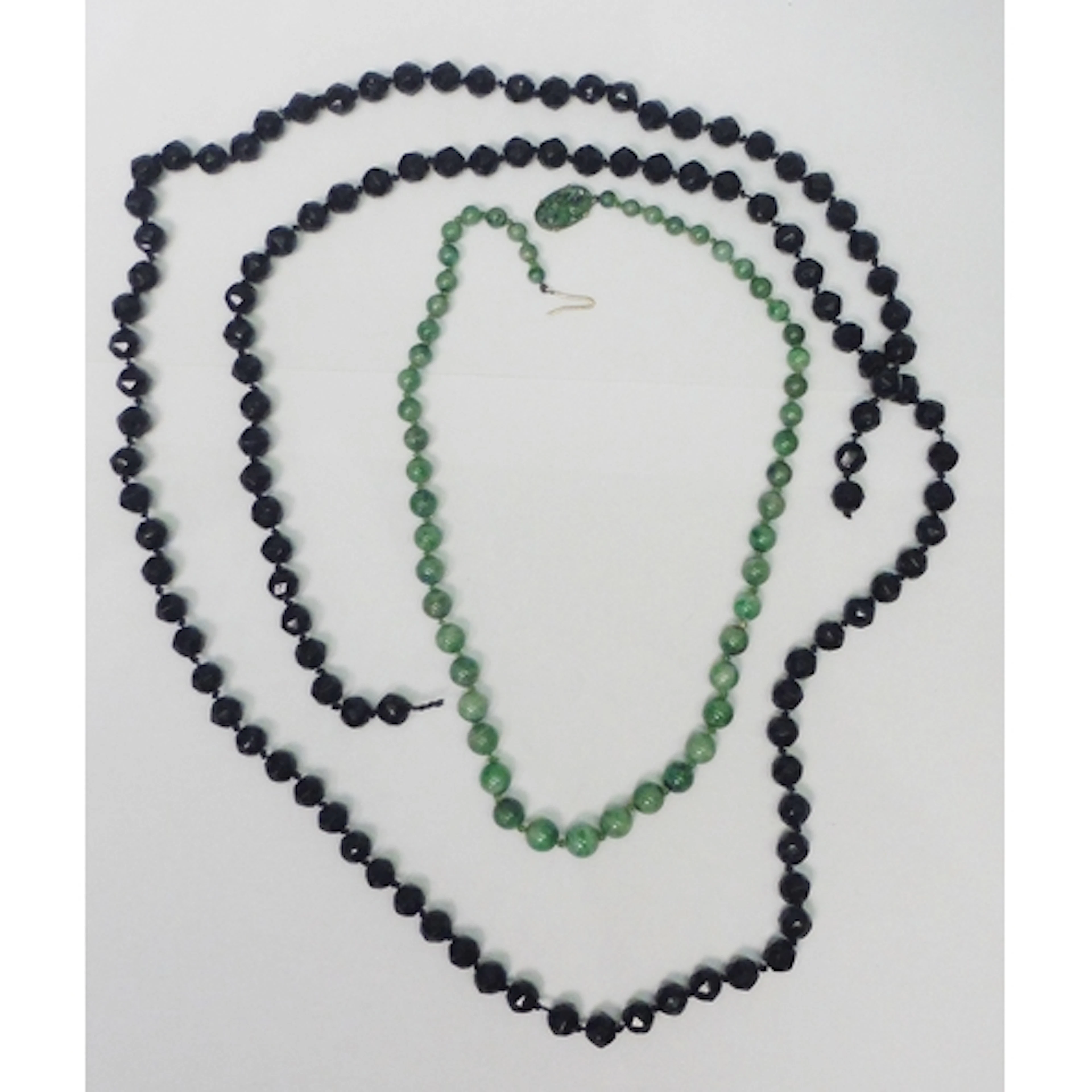A Chinese necklace of mottled jade beads fastening with an u...