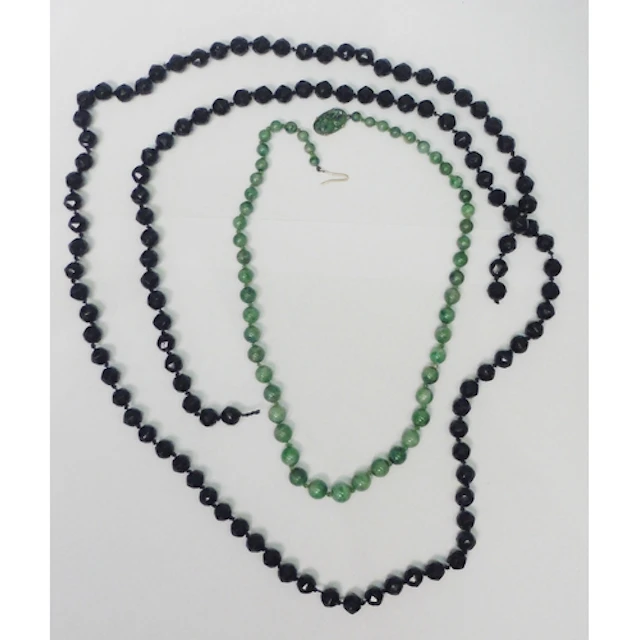 A Chinese necklace of mottled jade beads fastening with an u...
