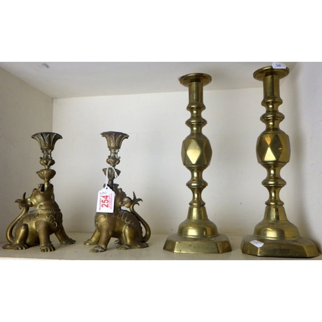 A pair of brass “dogs” candlesticks together with a pair of ...
