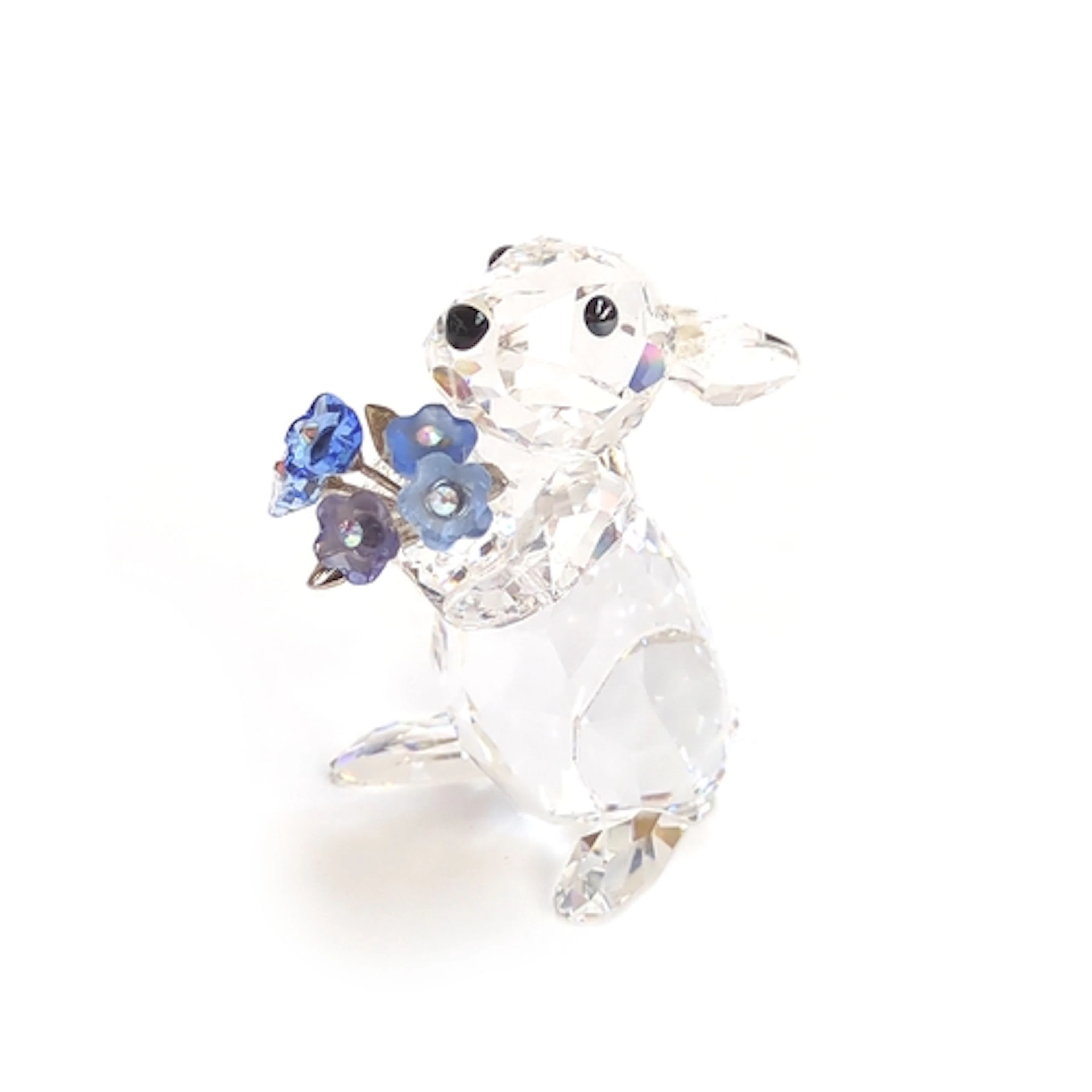A Swarovski crystal figurine of a rabbit holding forget-me-n...