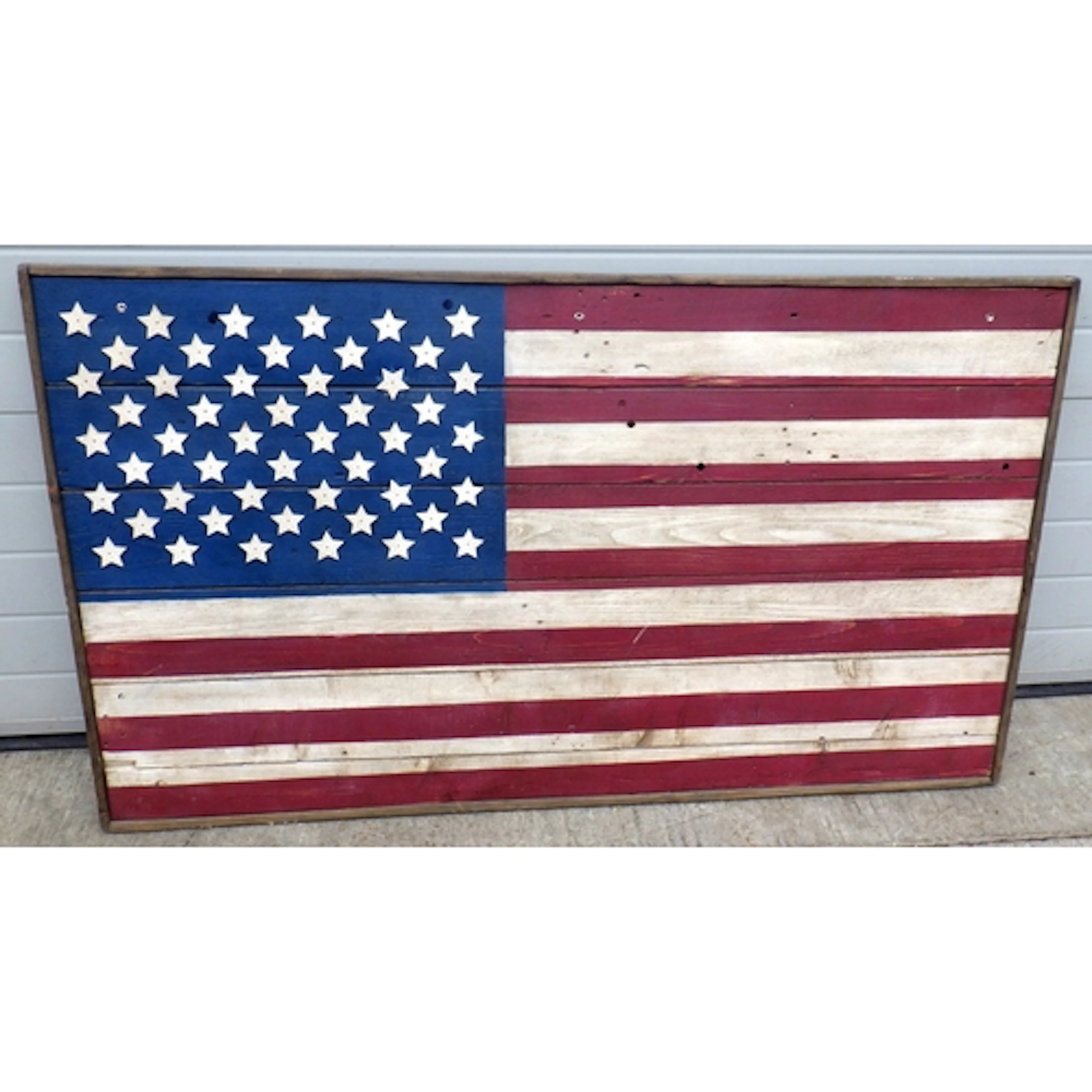 A wooden board painted with a stars & stripes American flag,...