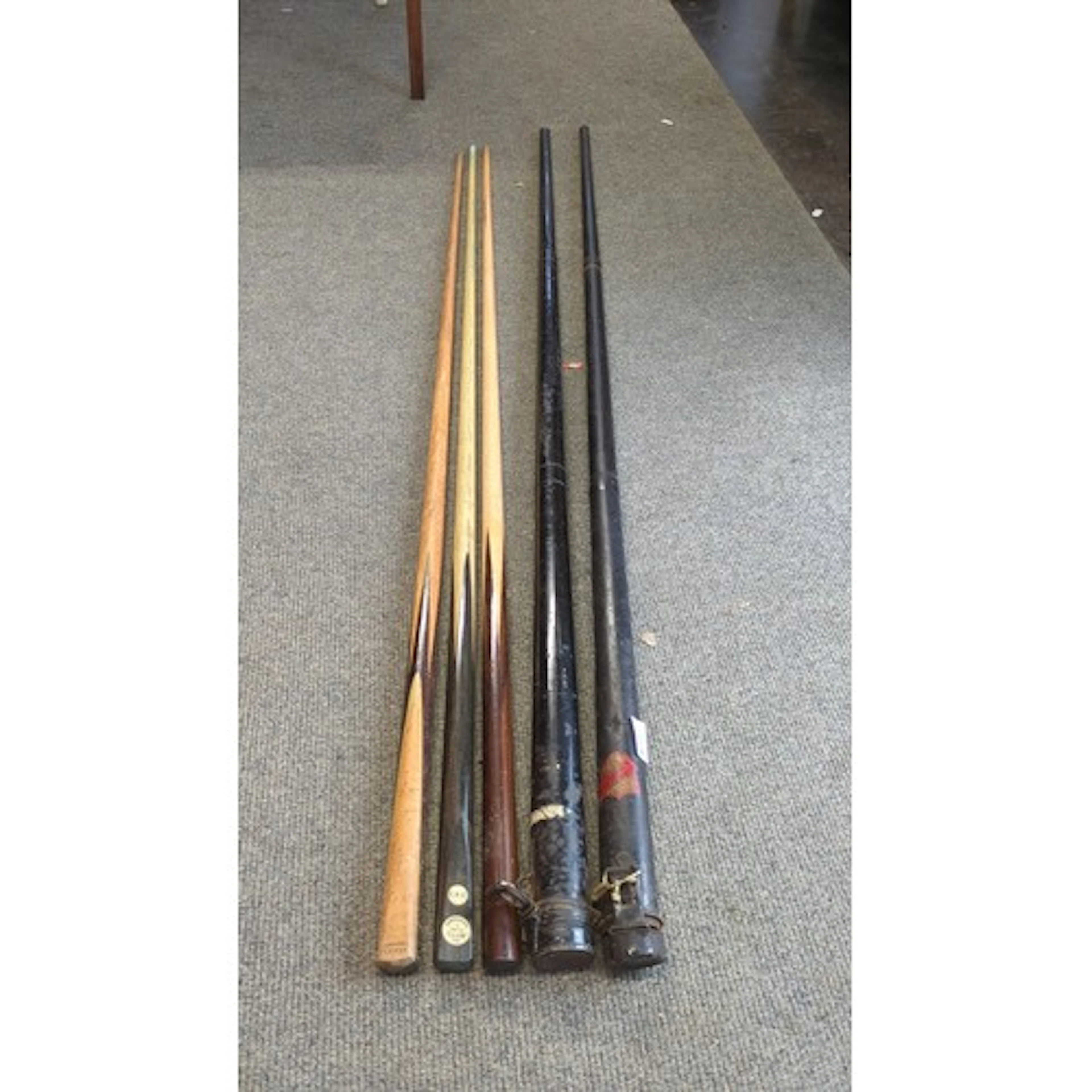 A group of vintage billiard and snooker cues, various woods,...