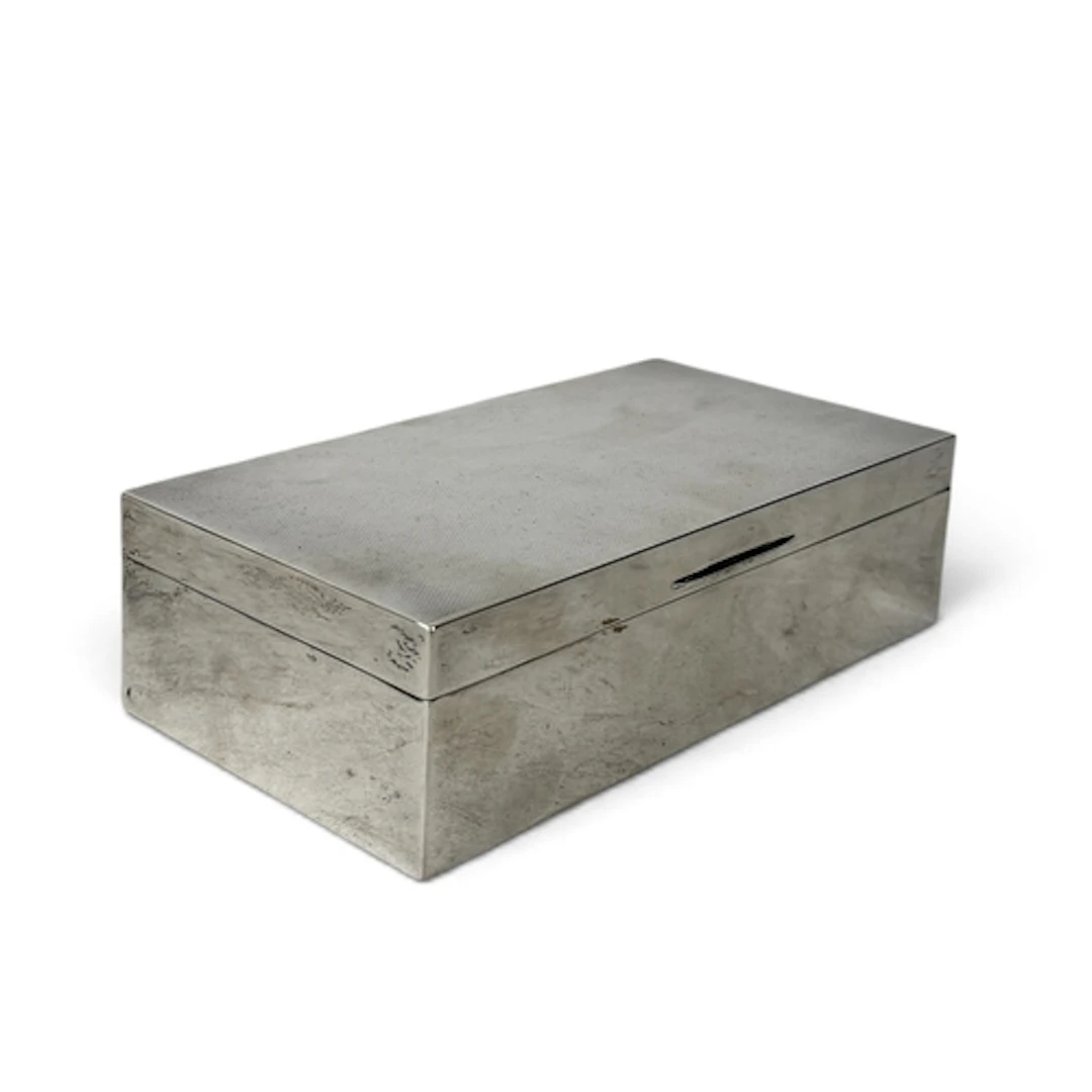 A RECTANGULAR SILVER CIGARETTE BOX, WITH HINGED ENGINE TURNE...